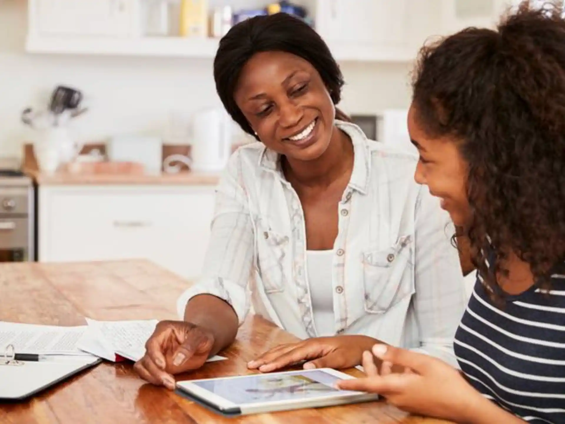a person showing a person something on a tablet