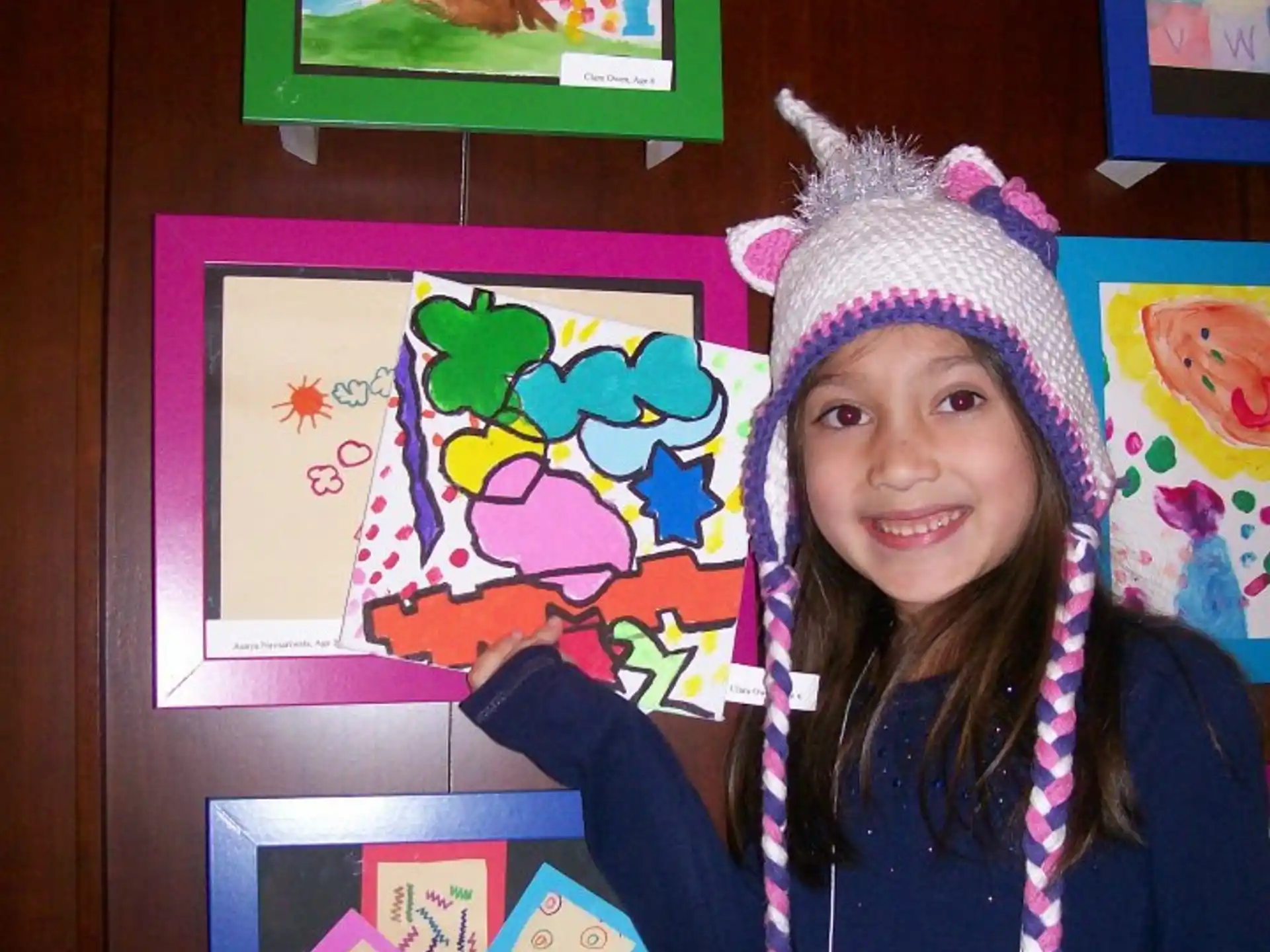 a girl wearing a hat and holding a book