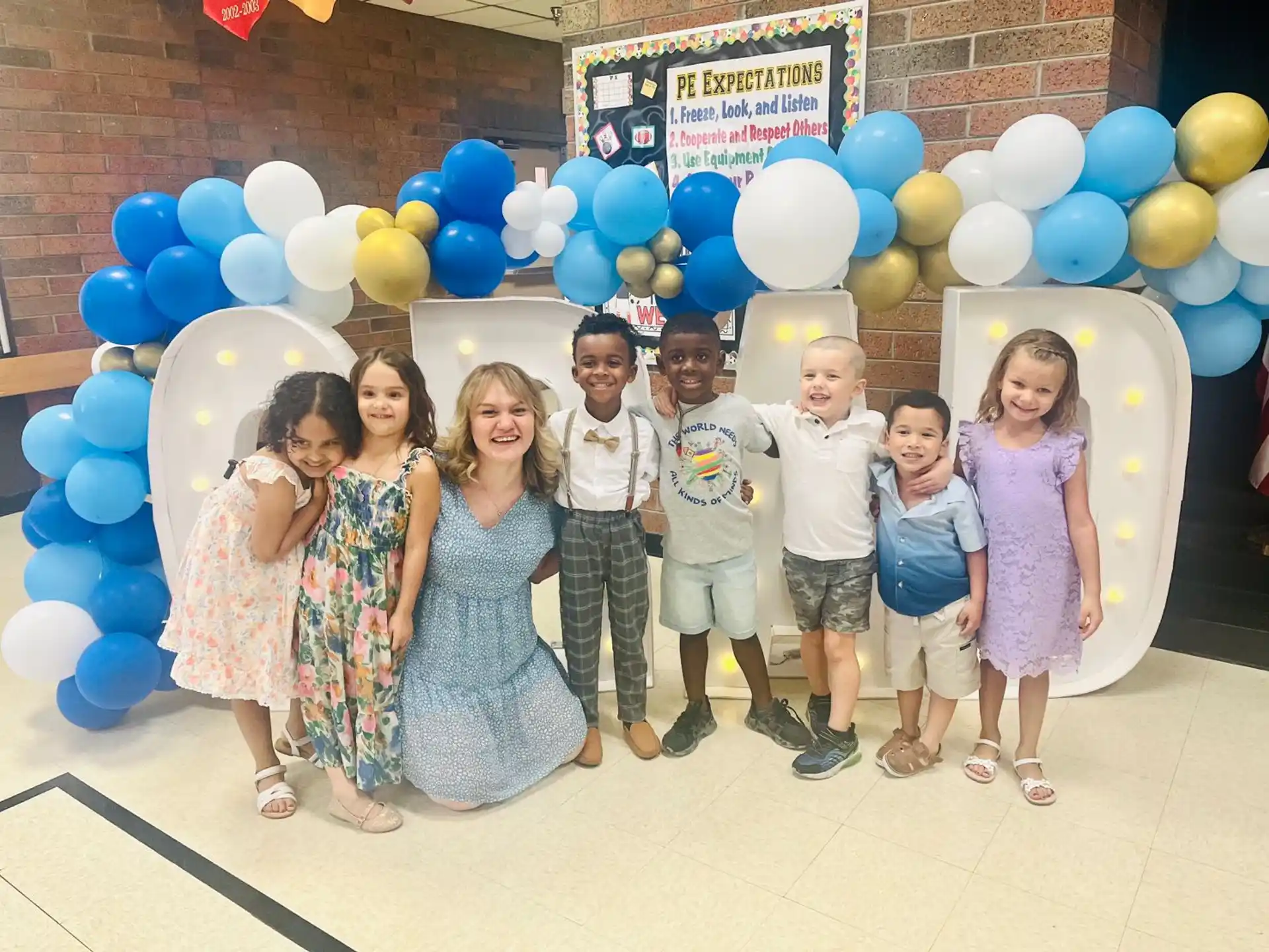 a group of children posing for a photo with balloons