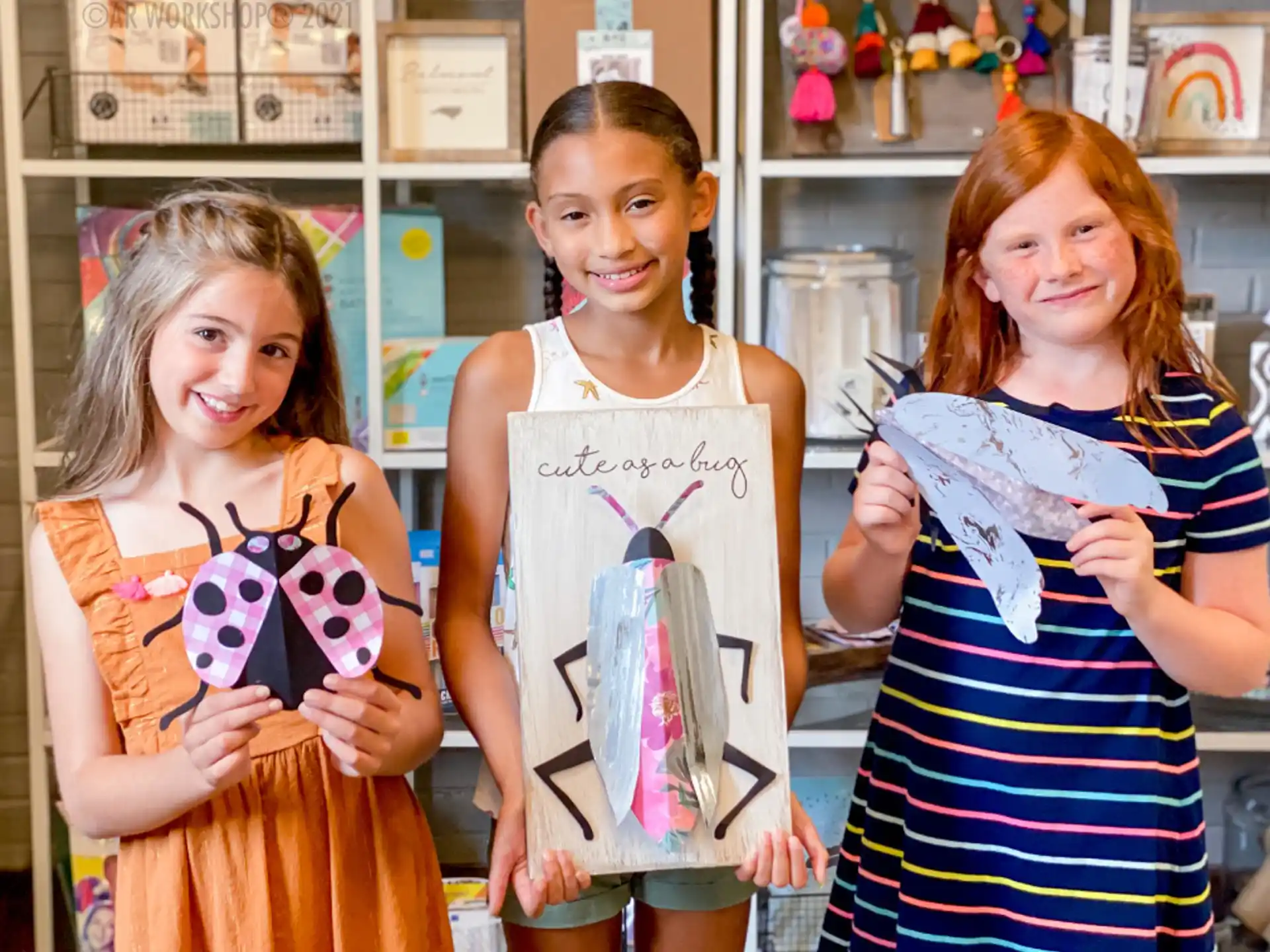 a group of girls holding up drawings