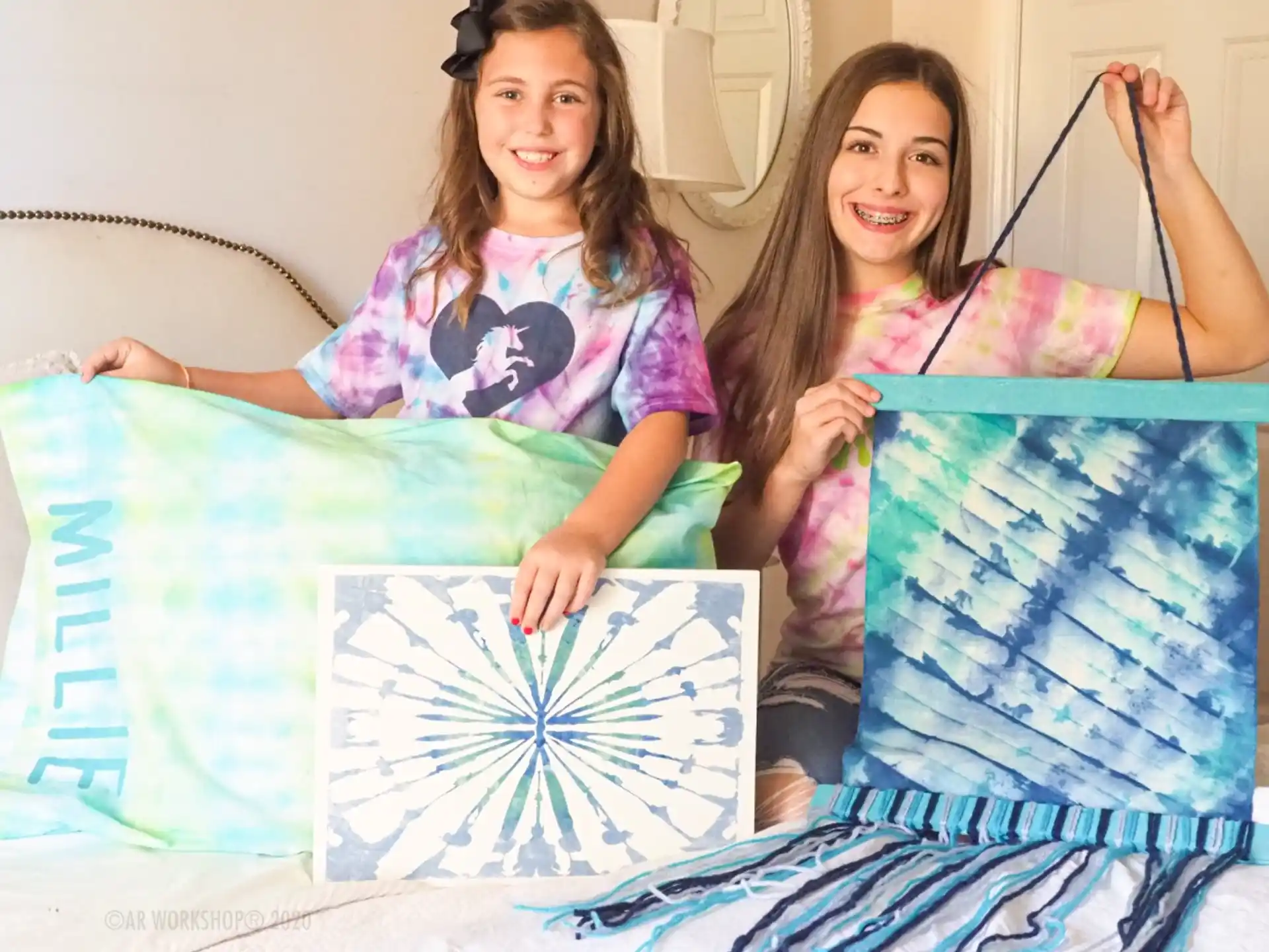two girls sitting on a bed
