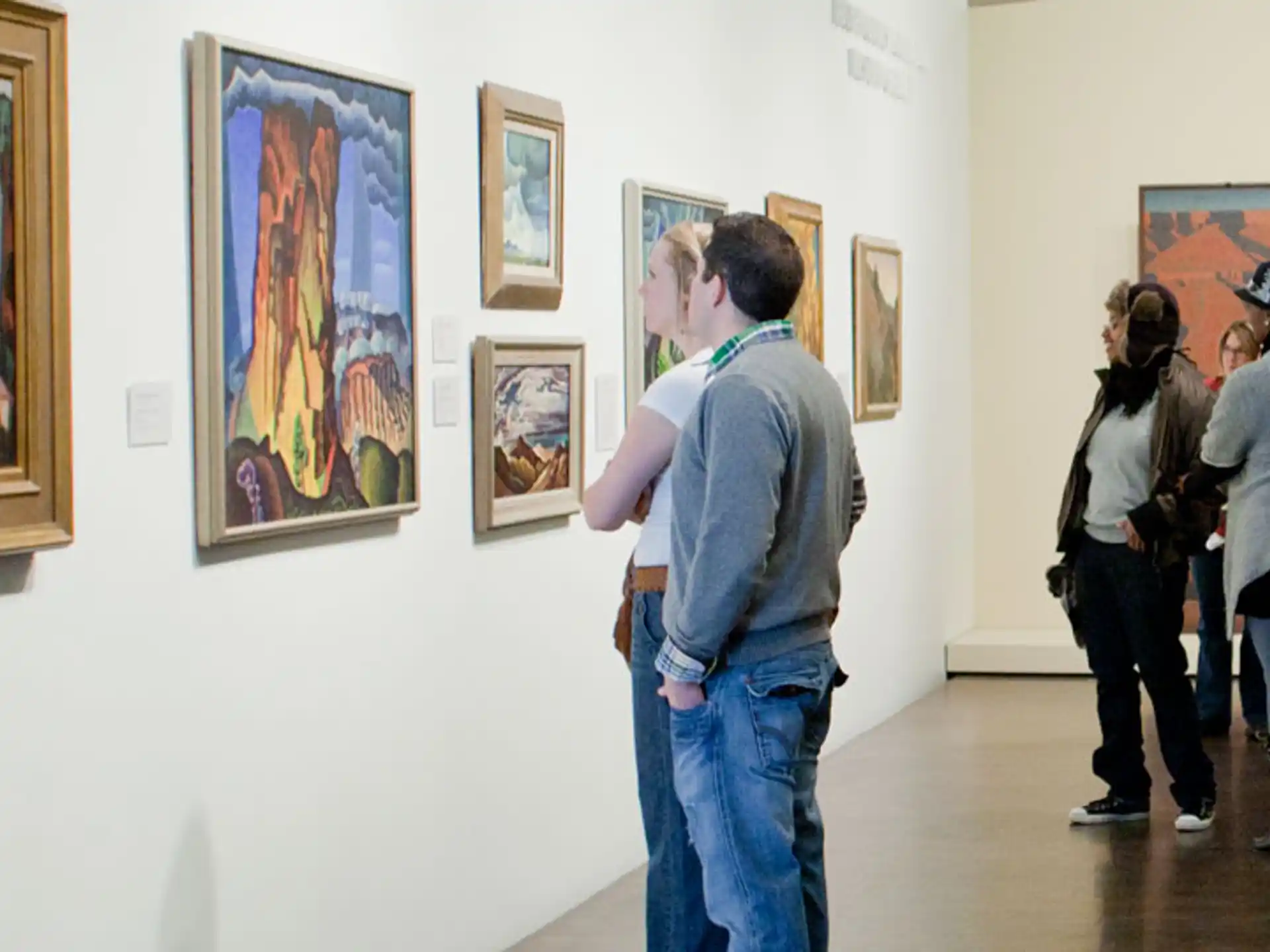 a group of people looking at art on the wall
