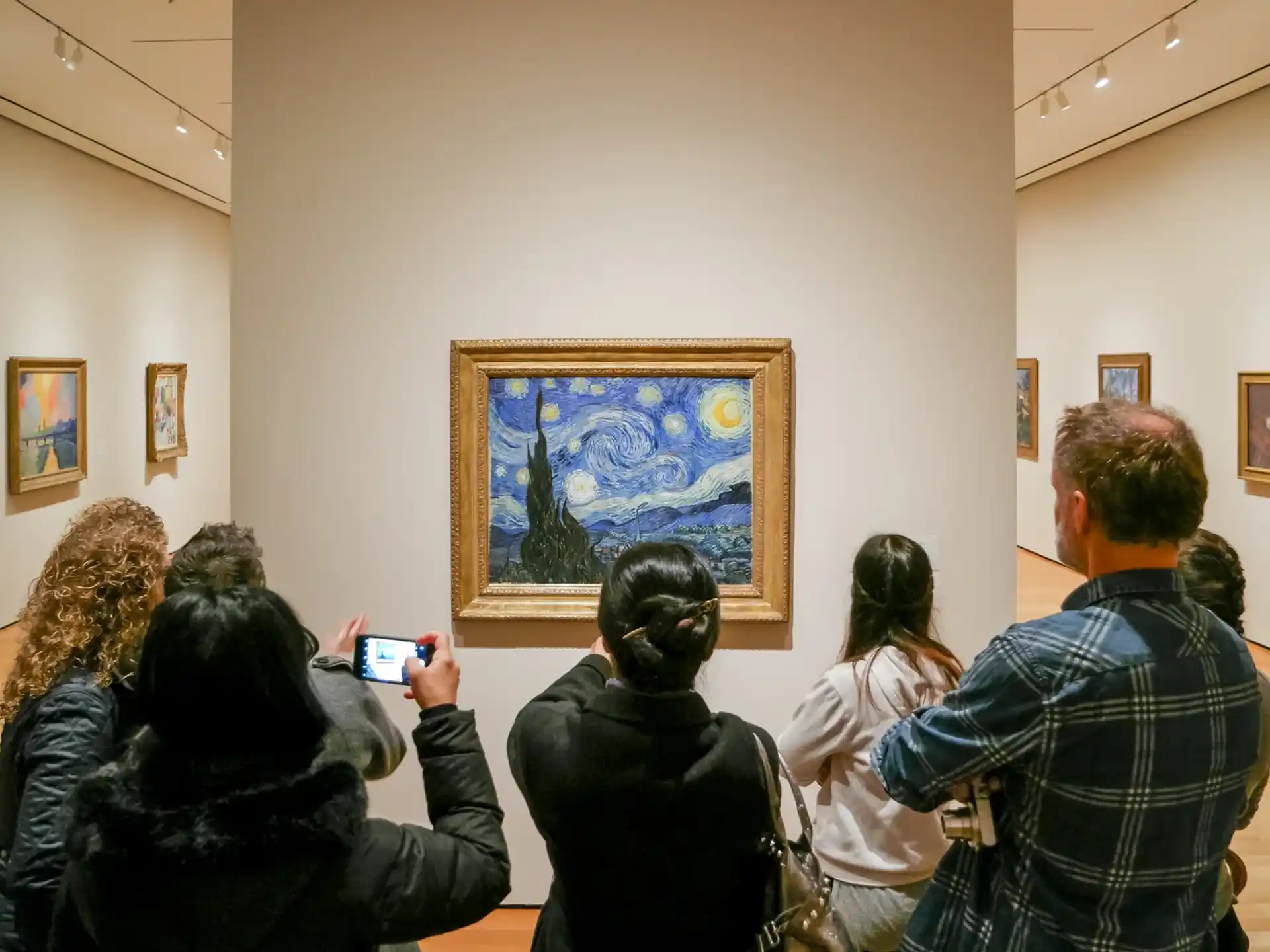 a group of people looking at art on the wall