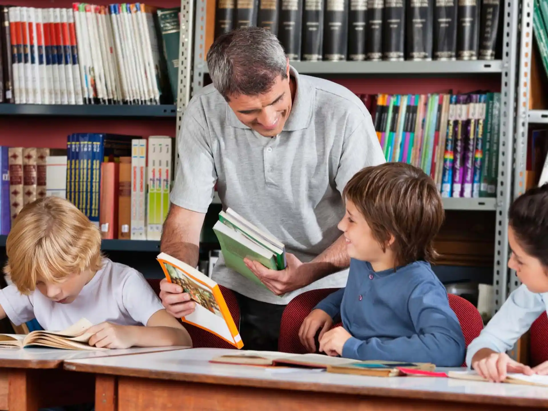 a man reading a book to a few kids
