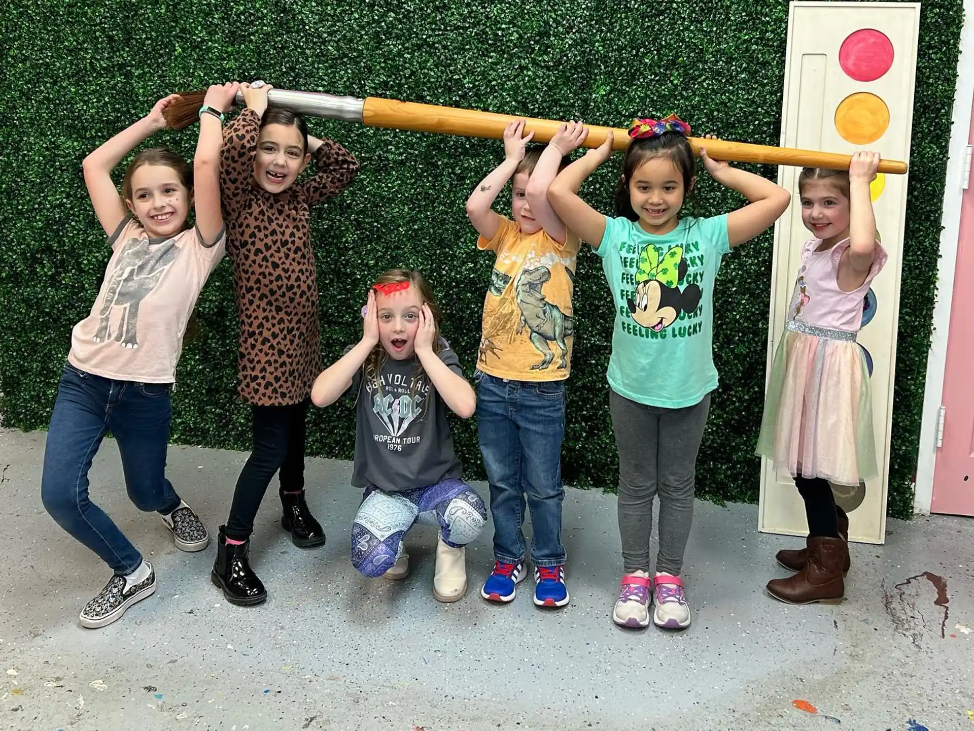 a group of children holding a wooden pole