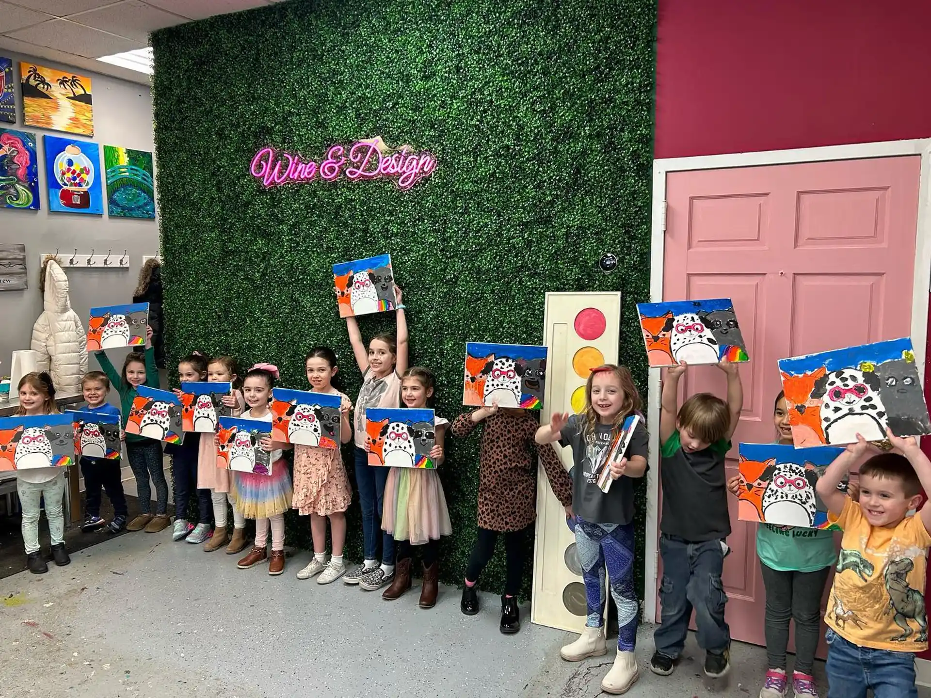 a group of children posing for a photo in front of a green wall