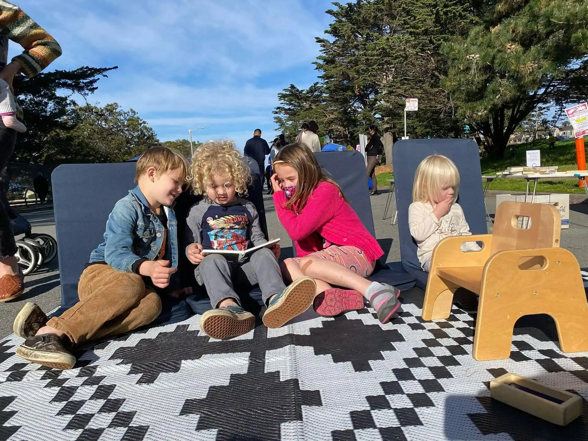 a group of children sitting on the ground outside