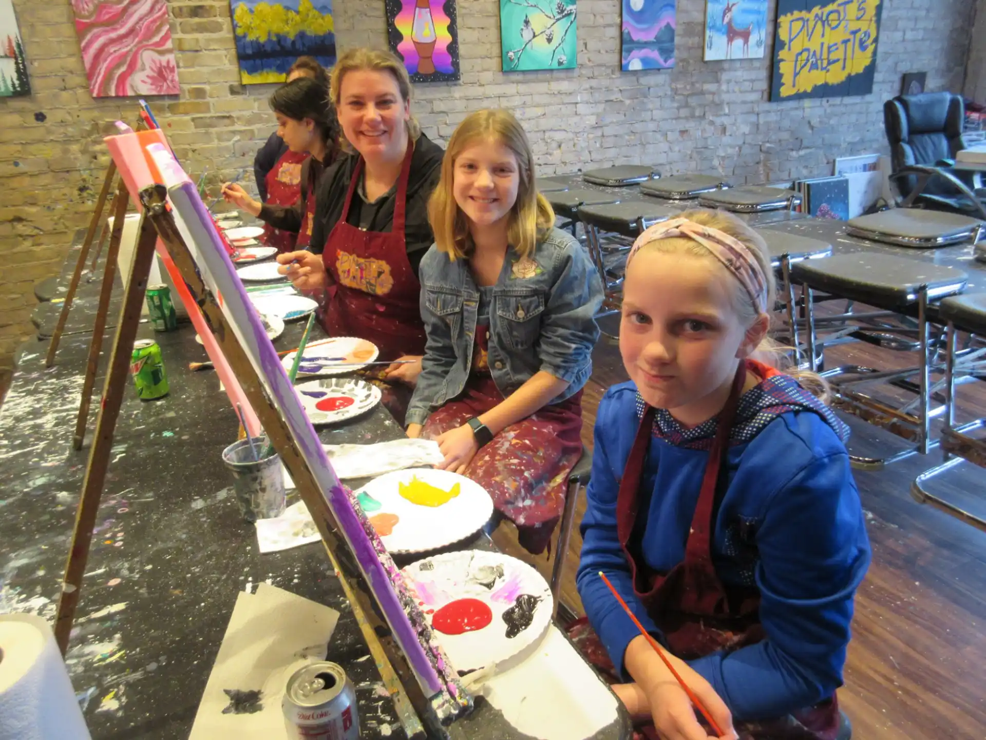 a group of girls sitting at a table with food