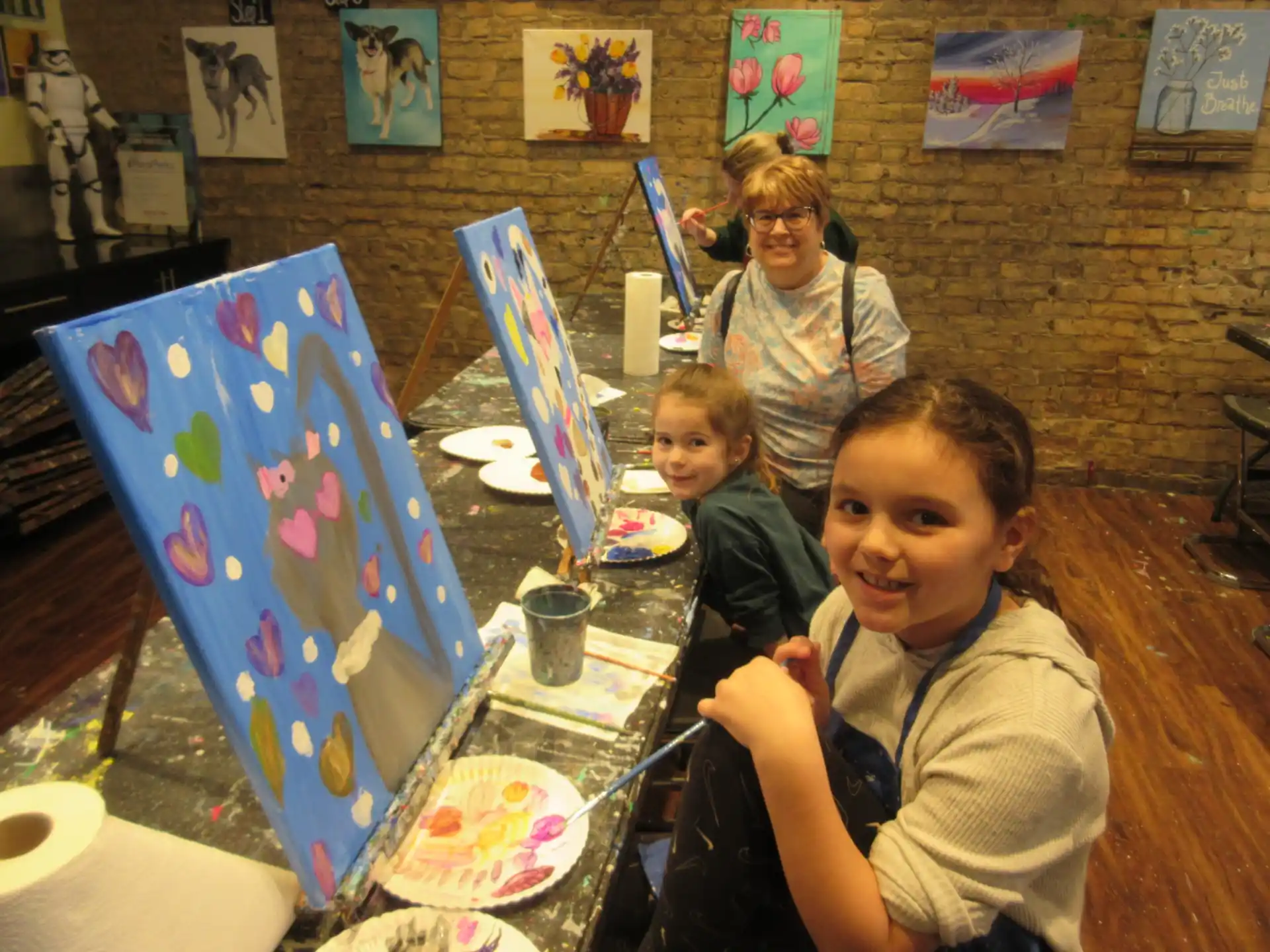 a group of people sitting at a table with art on it