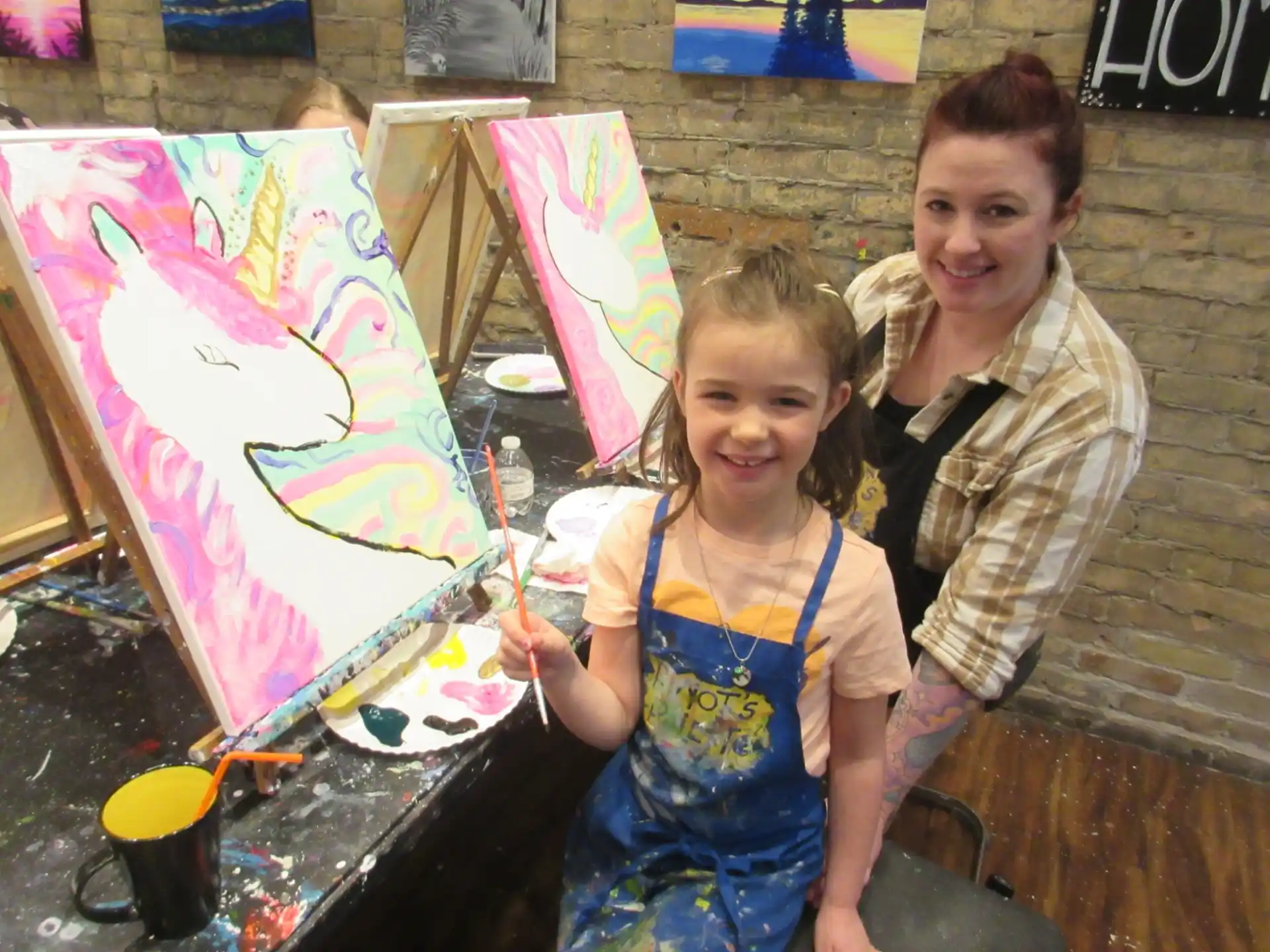 a person and a girl holding a painting