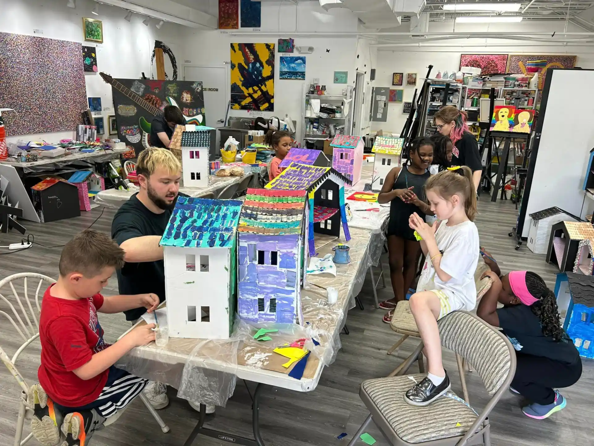 a group of people sitting at a table with a large display of toys