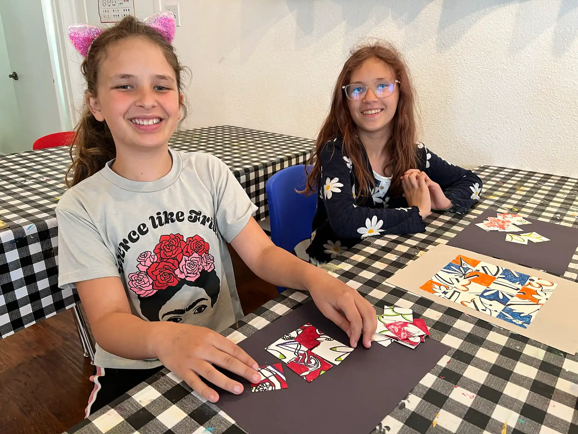 a couple of girls sitting at a table with a board game