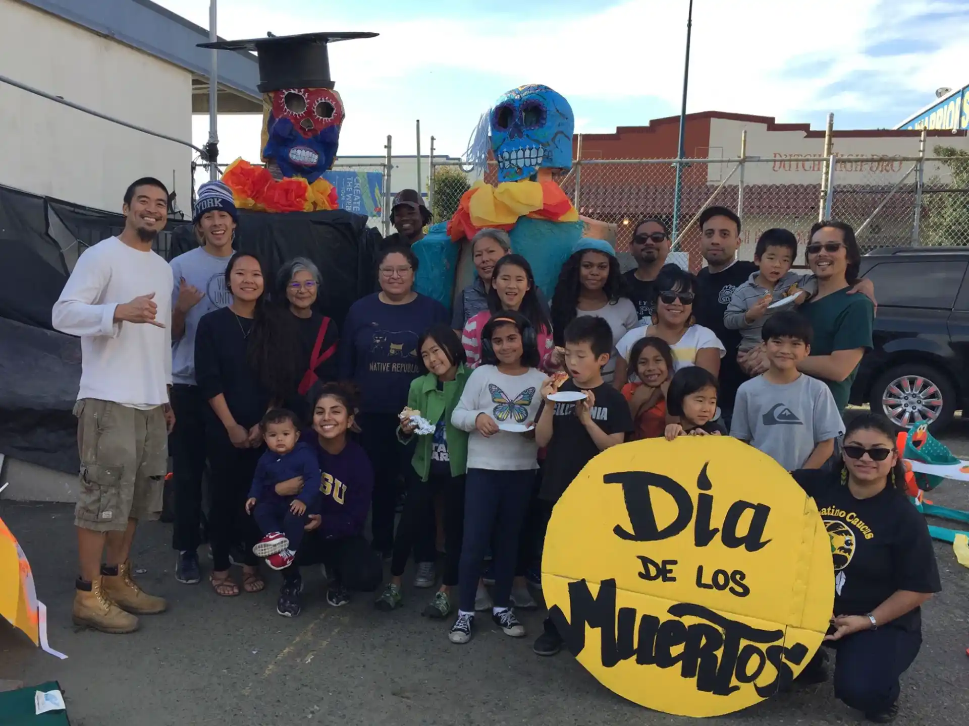 a group of people posing for a photo with a sign