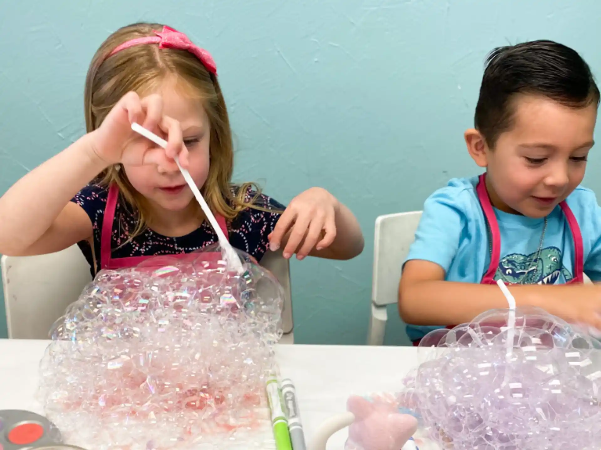 a couple of children playing with a plastic bag of ice cream