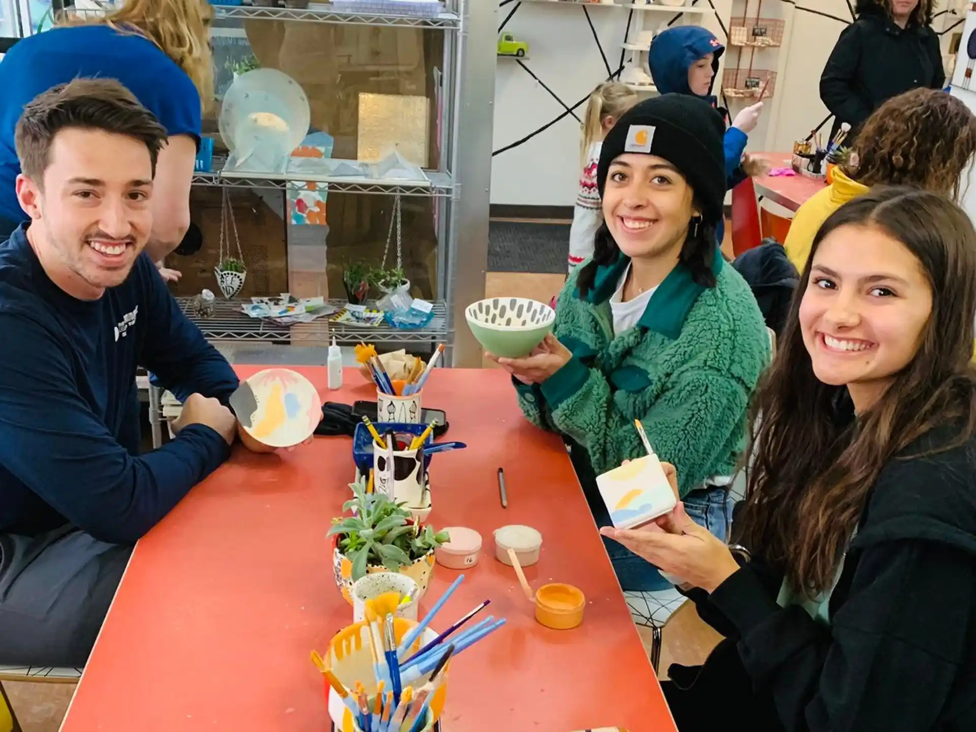 a group of people sitting at a table with food and drinks