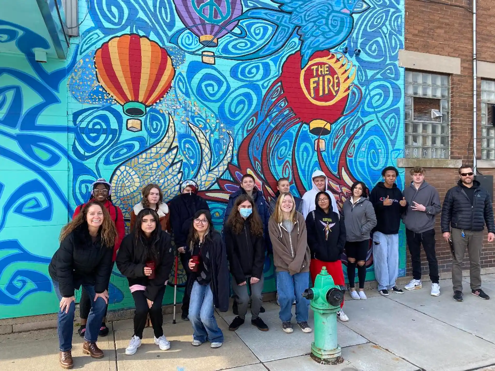 a group of people standing in front of a wall with graffiti