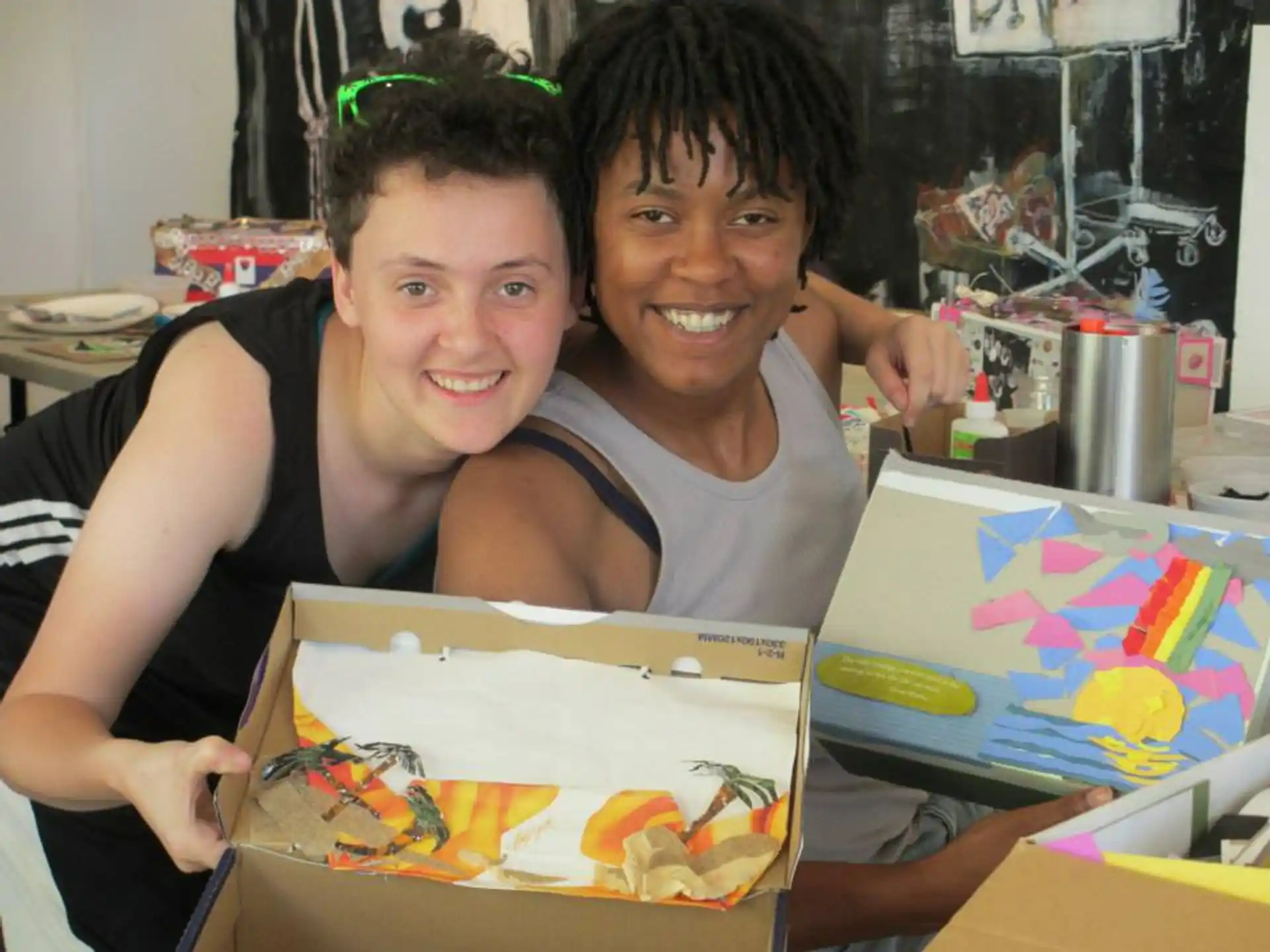 a couple of people holding a box of cookies