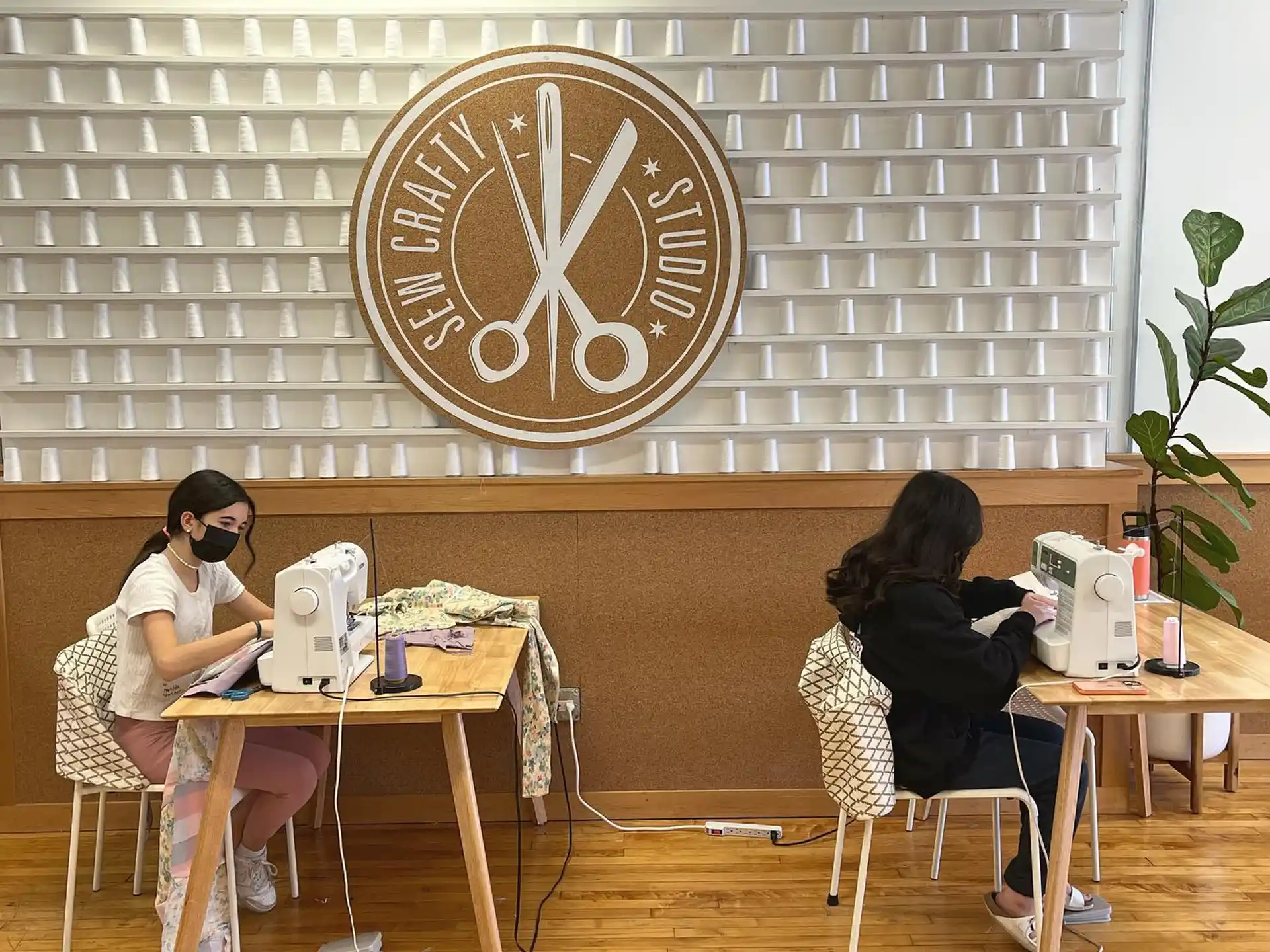 a couple of women sitting at a table with computers