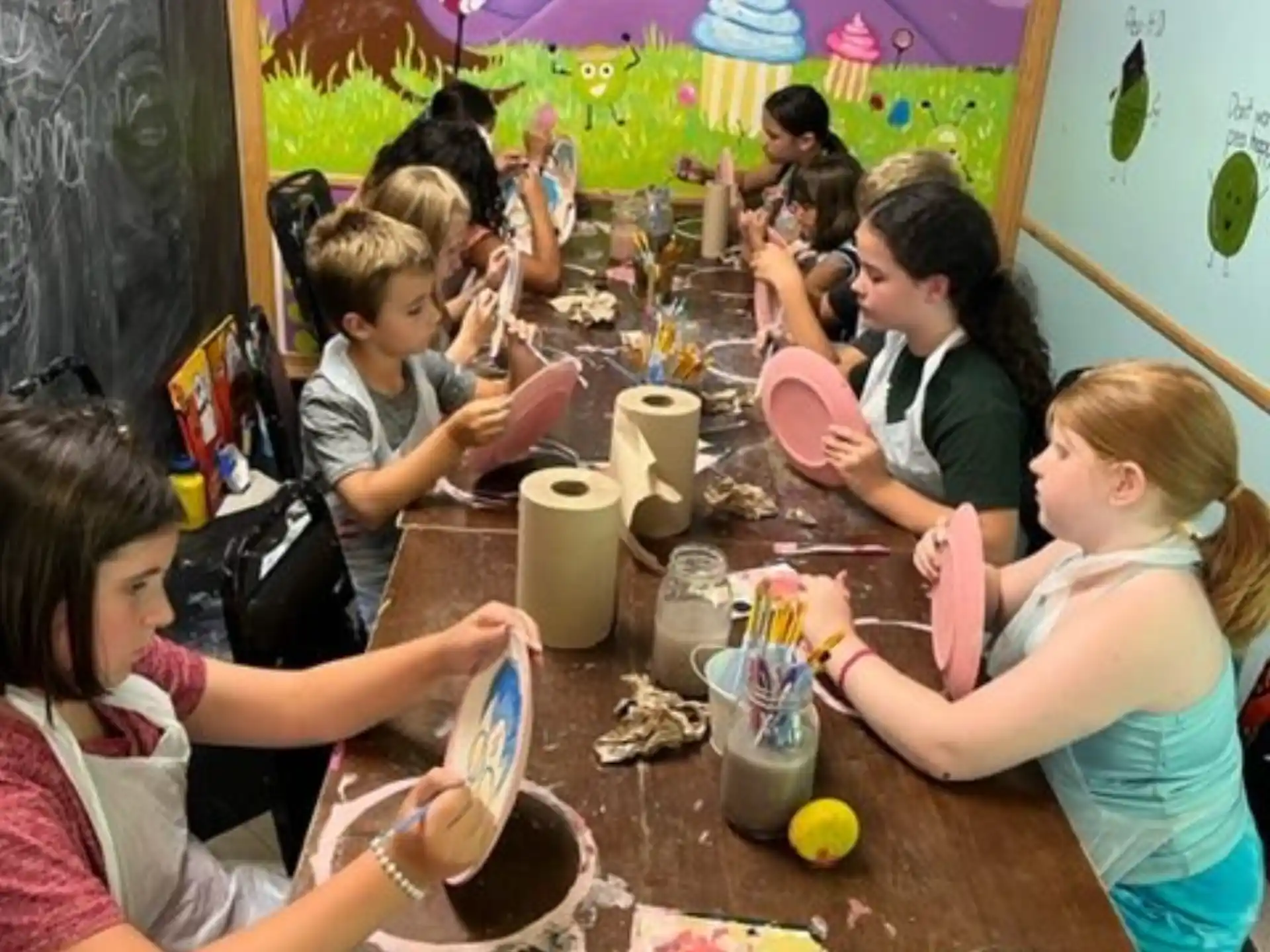 a group of children sitting at a table eating food