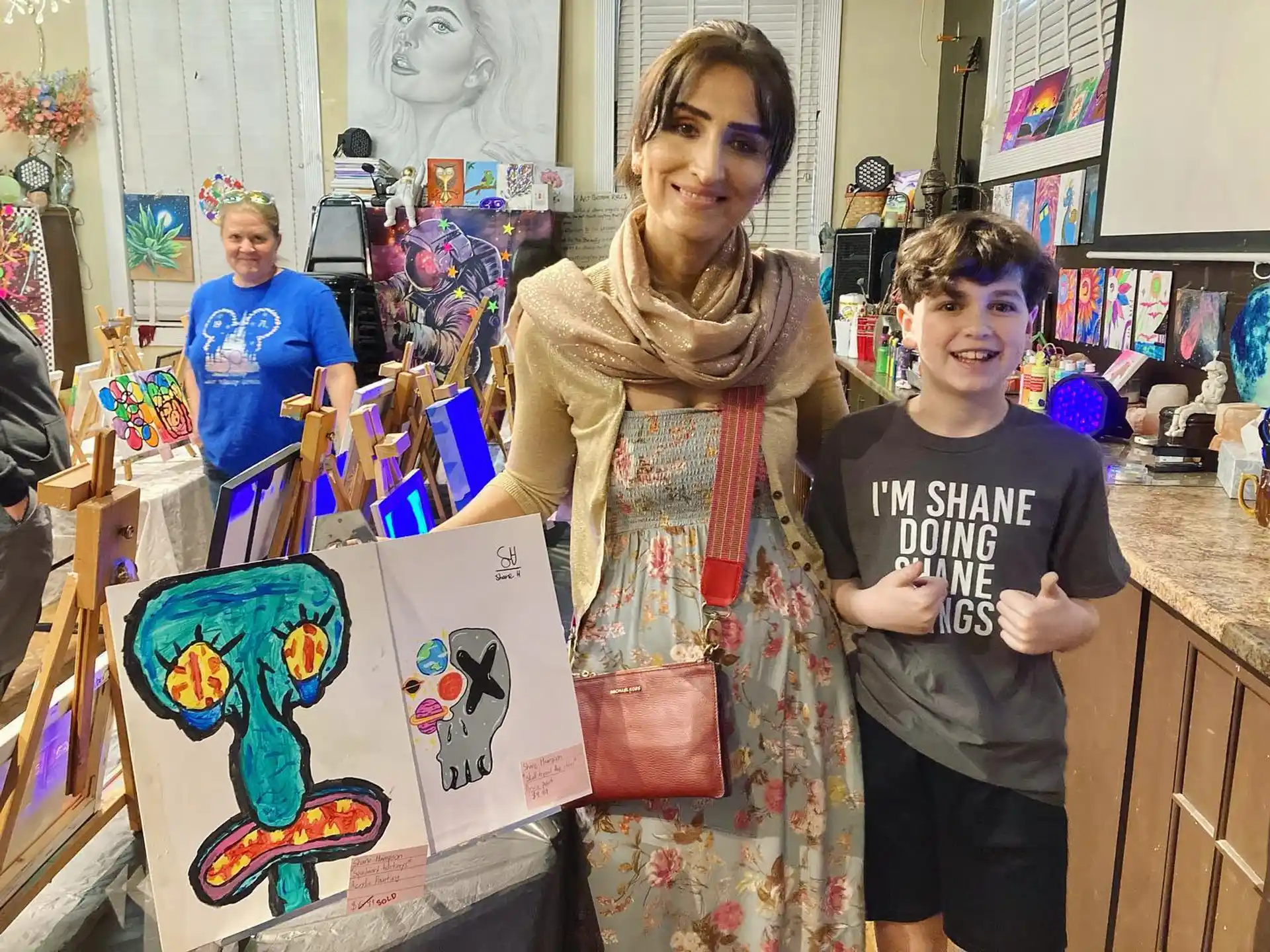 a person and a boy holding a drawing