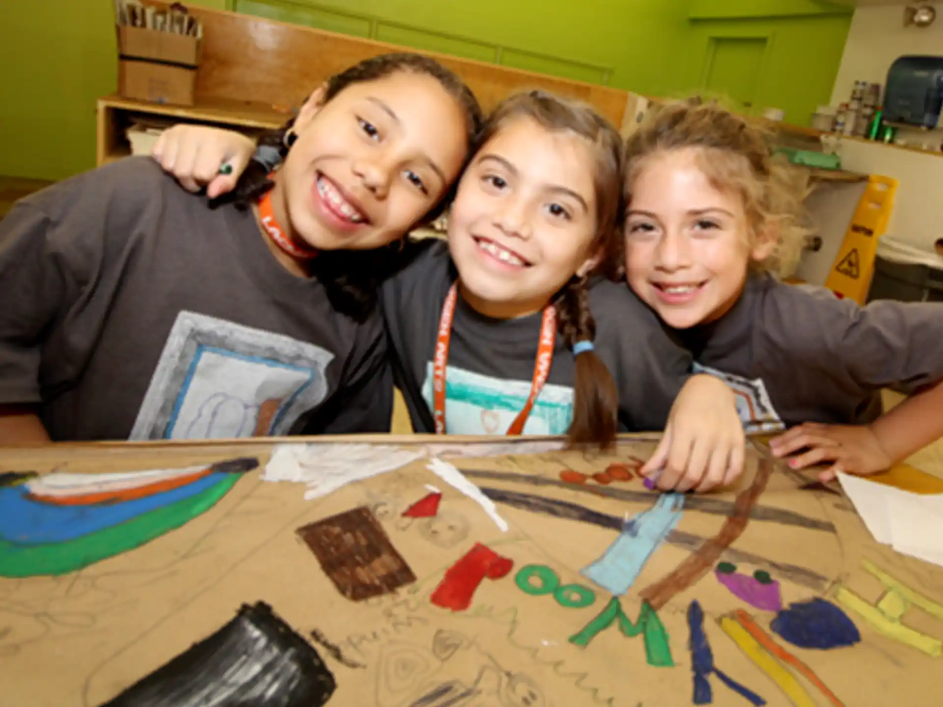 a group of kids sitting at a table with a puzzle