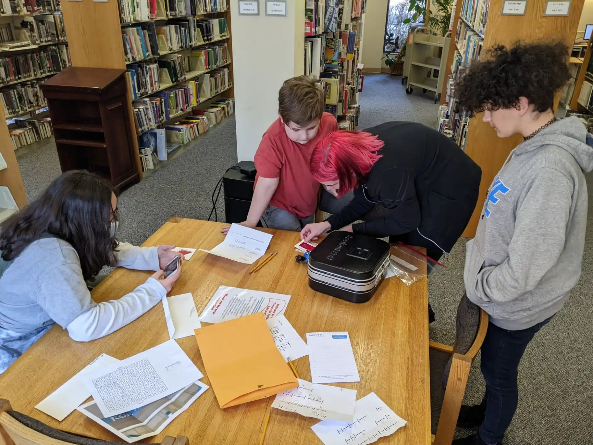 a group of people sitting around a table with books on it