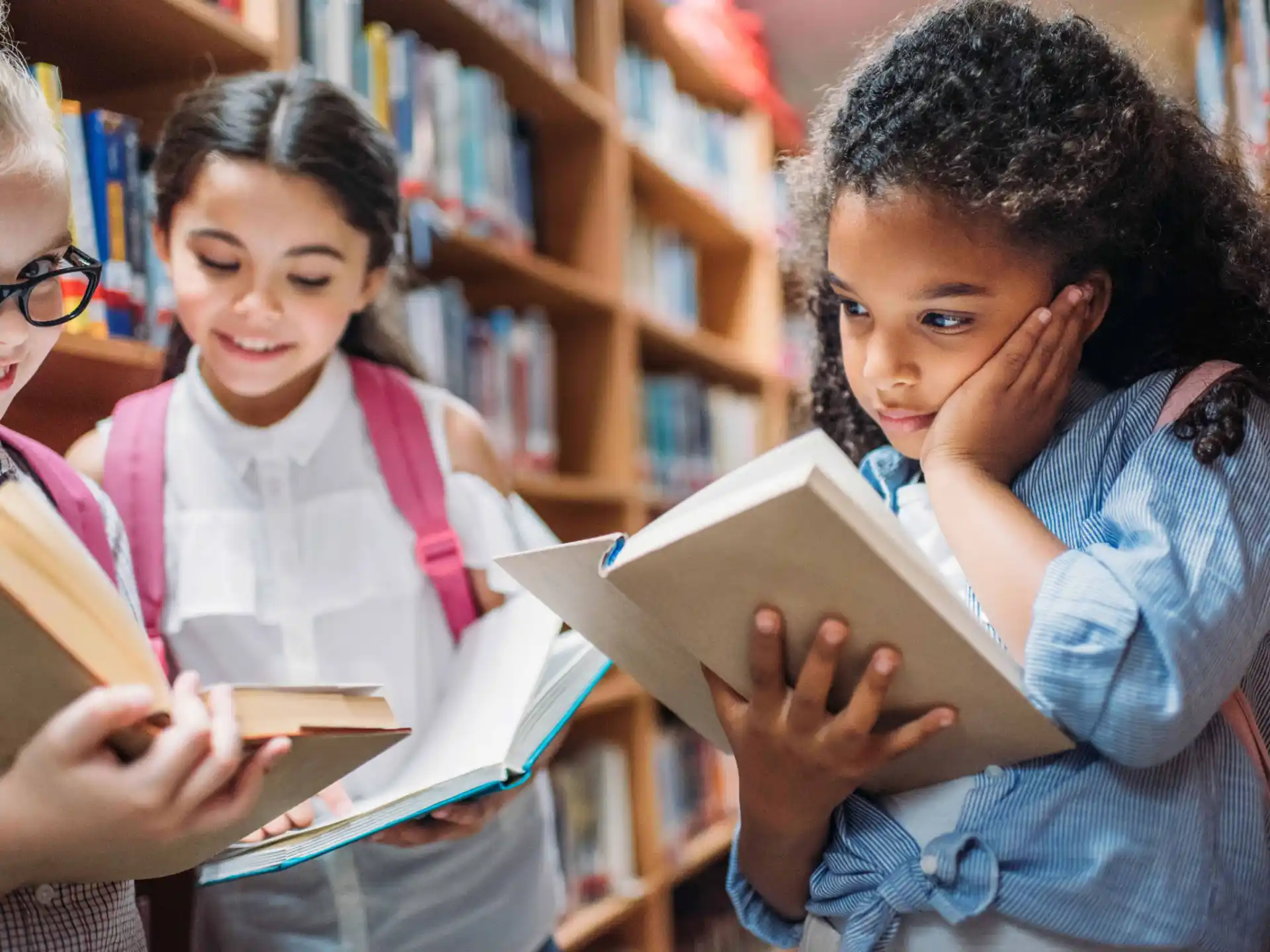 a group of young girls reading a book