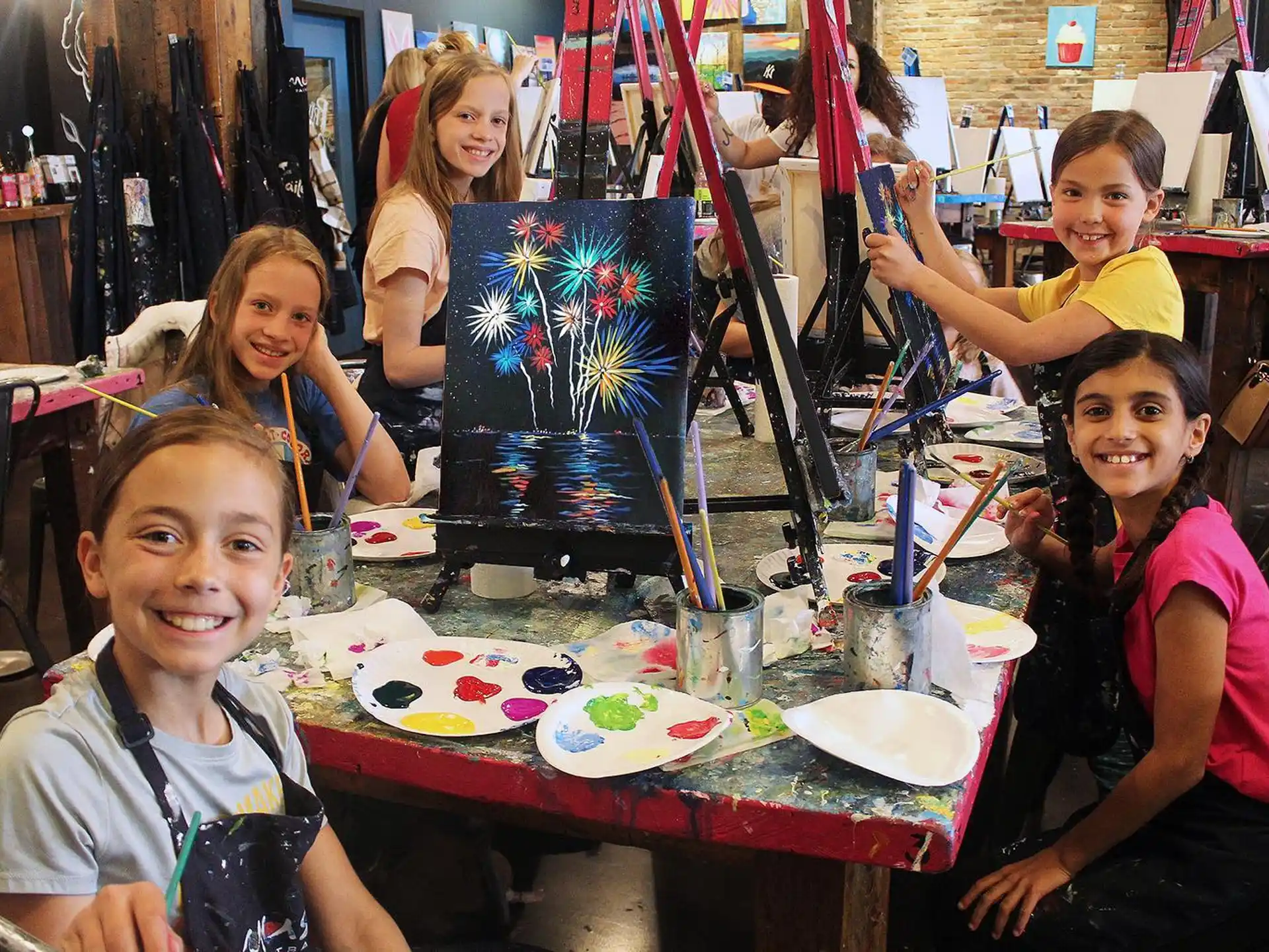 a group of kids sitting at a table with a tv