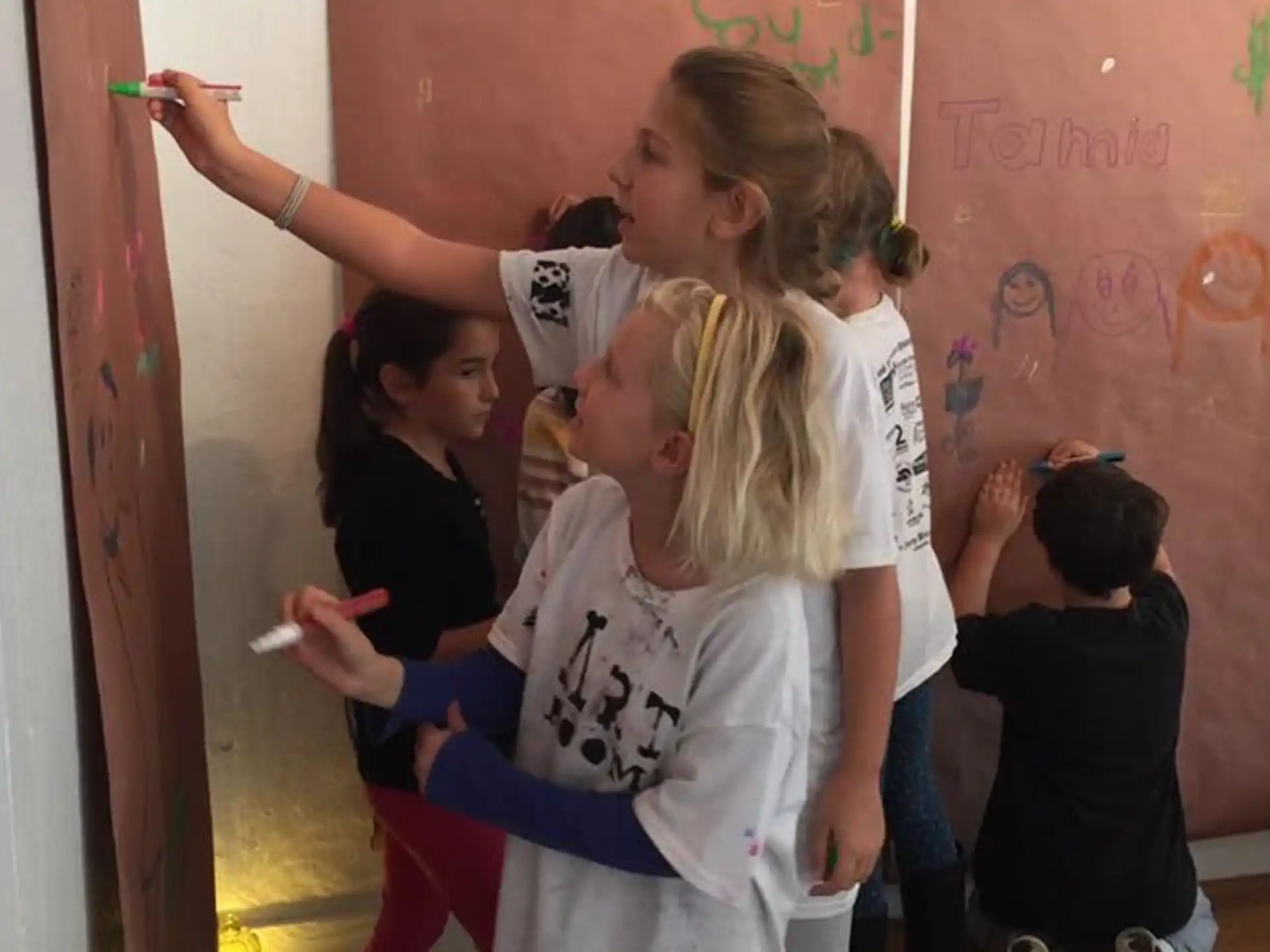 a group of young girls writing on a whiteboard