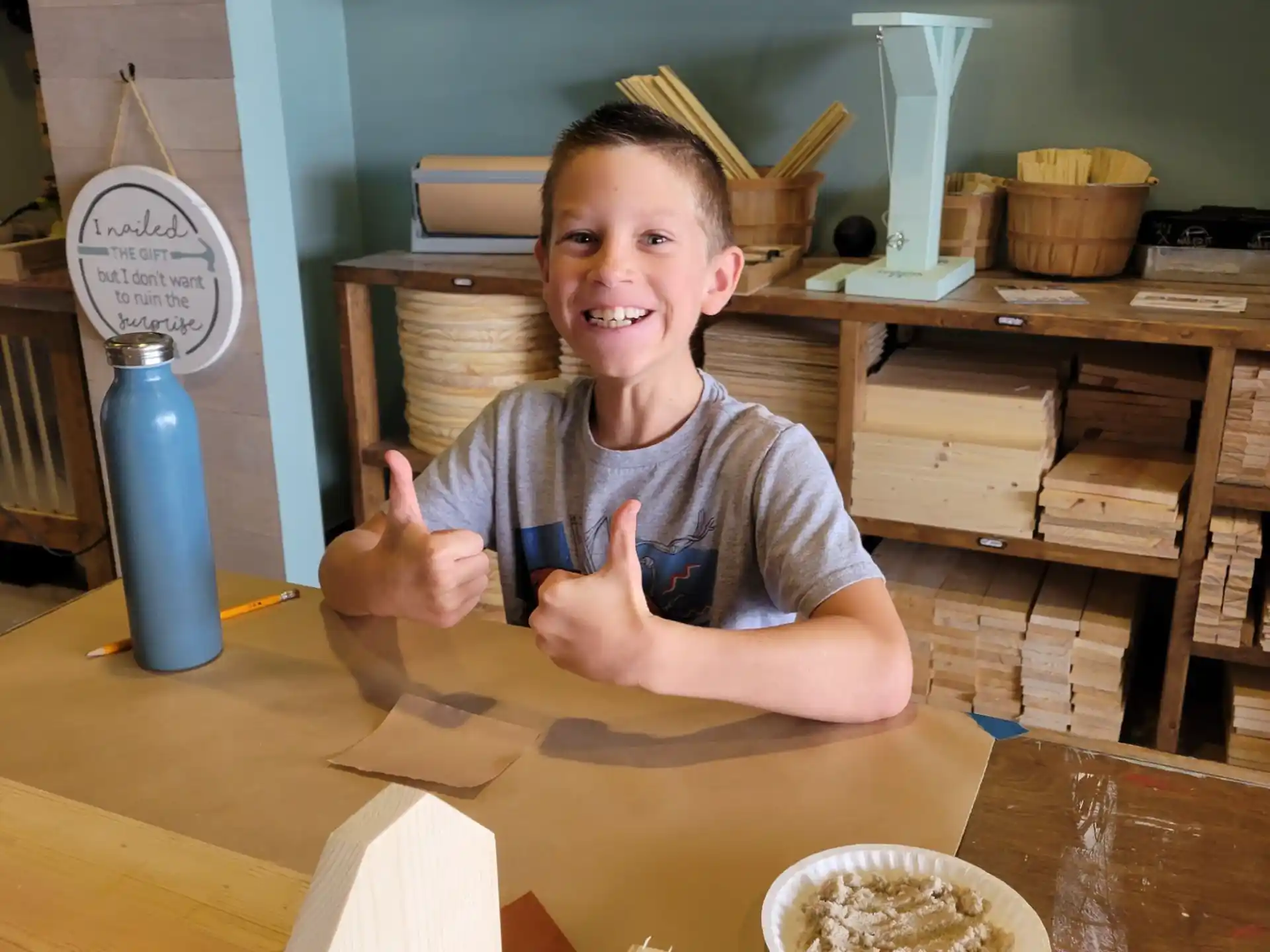 a boy sitting at a table with a bowl of cereal and a bowl of milk
