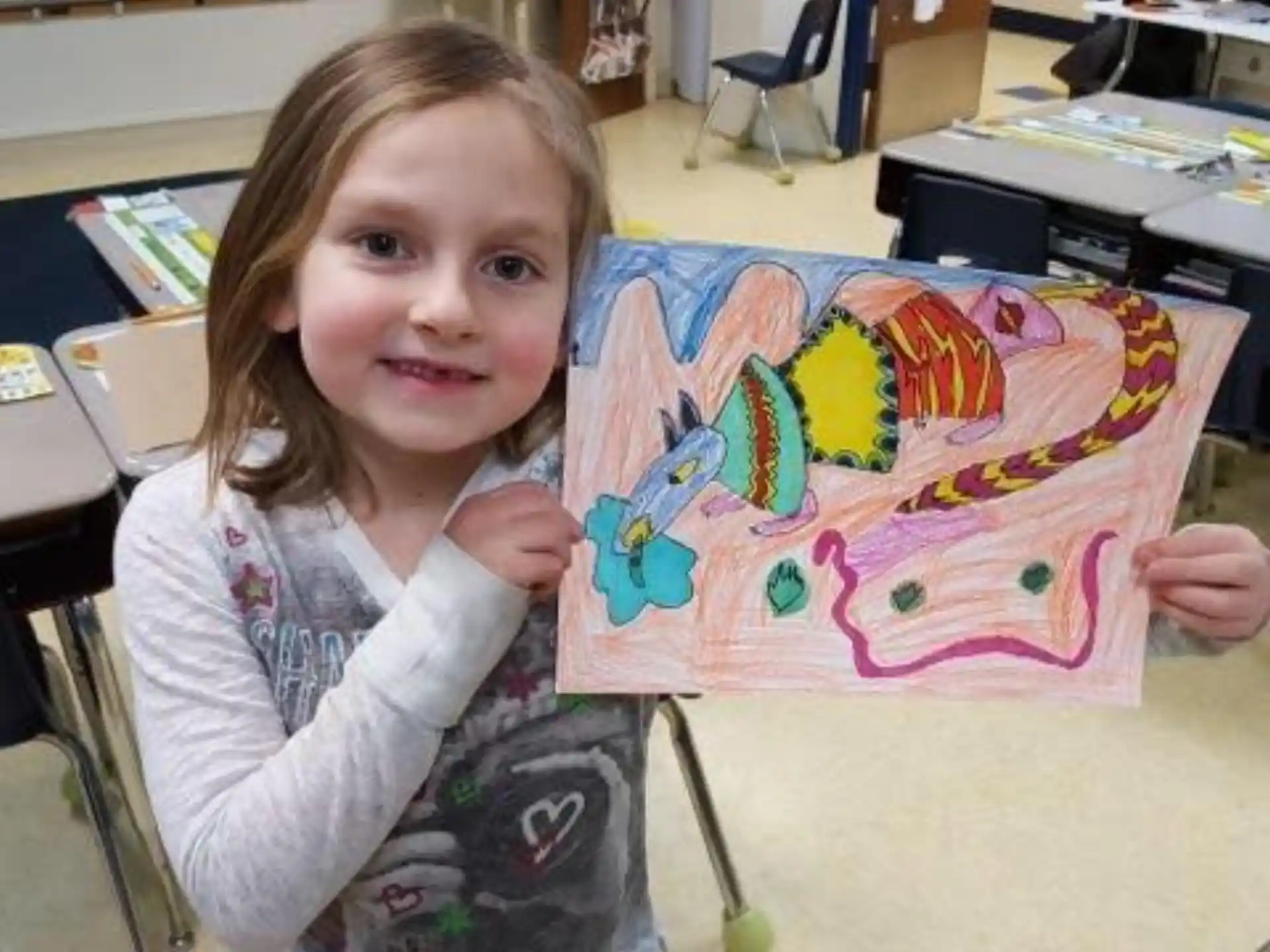 a girl holding a colorful piece of art