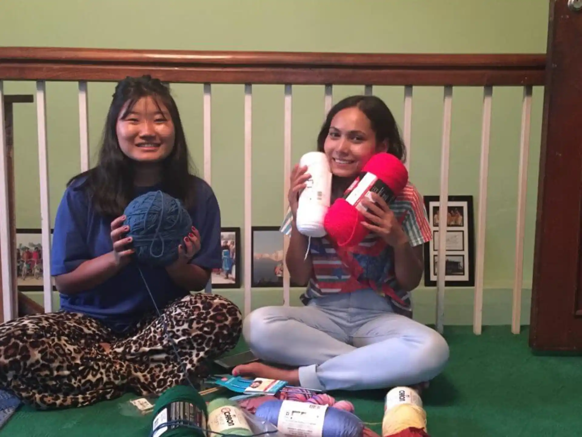 a person and a girl sitting on the floor and holding up a red and white object