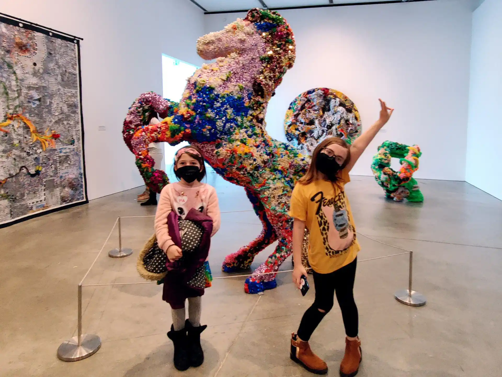 a couple of people posing for the camera in front of a large sculpture