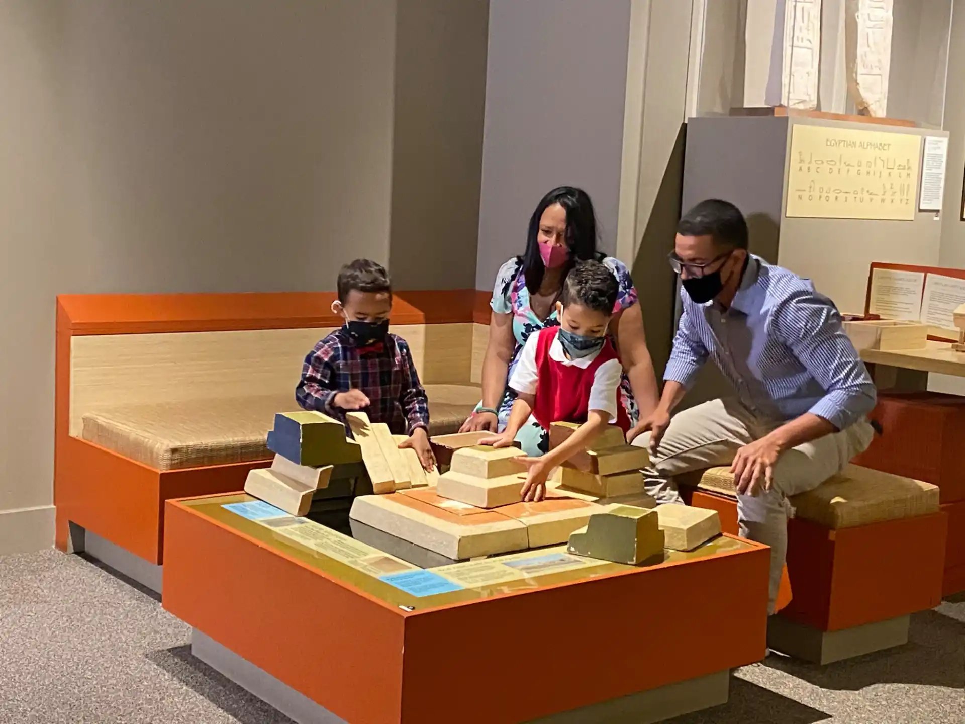 a group of people sitting on a bench with a toy train