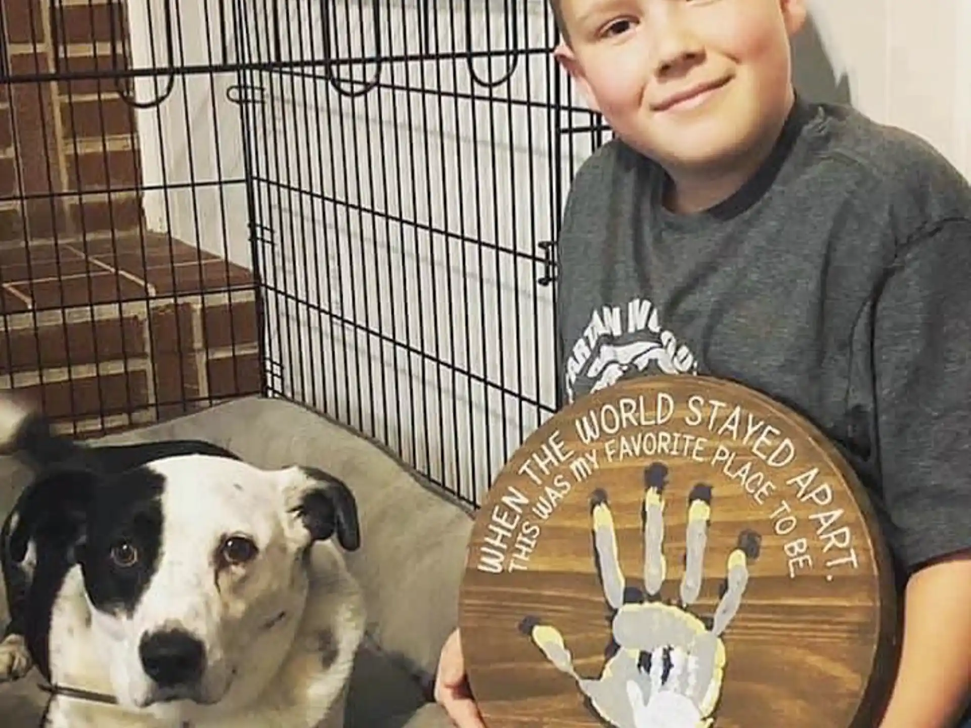 a boy holding a plaque with a dog in the background