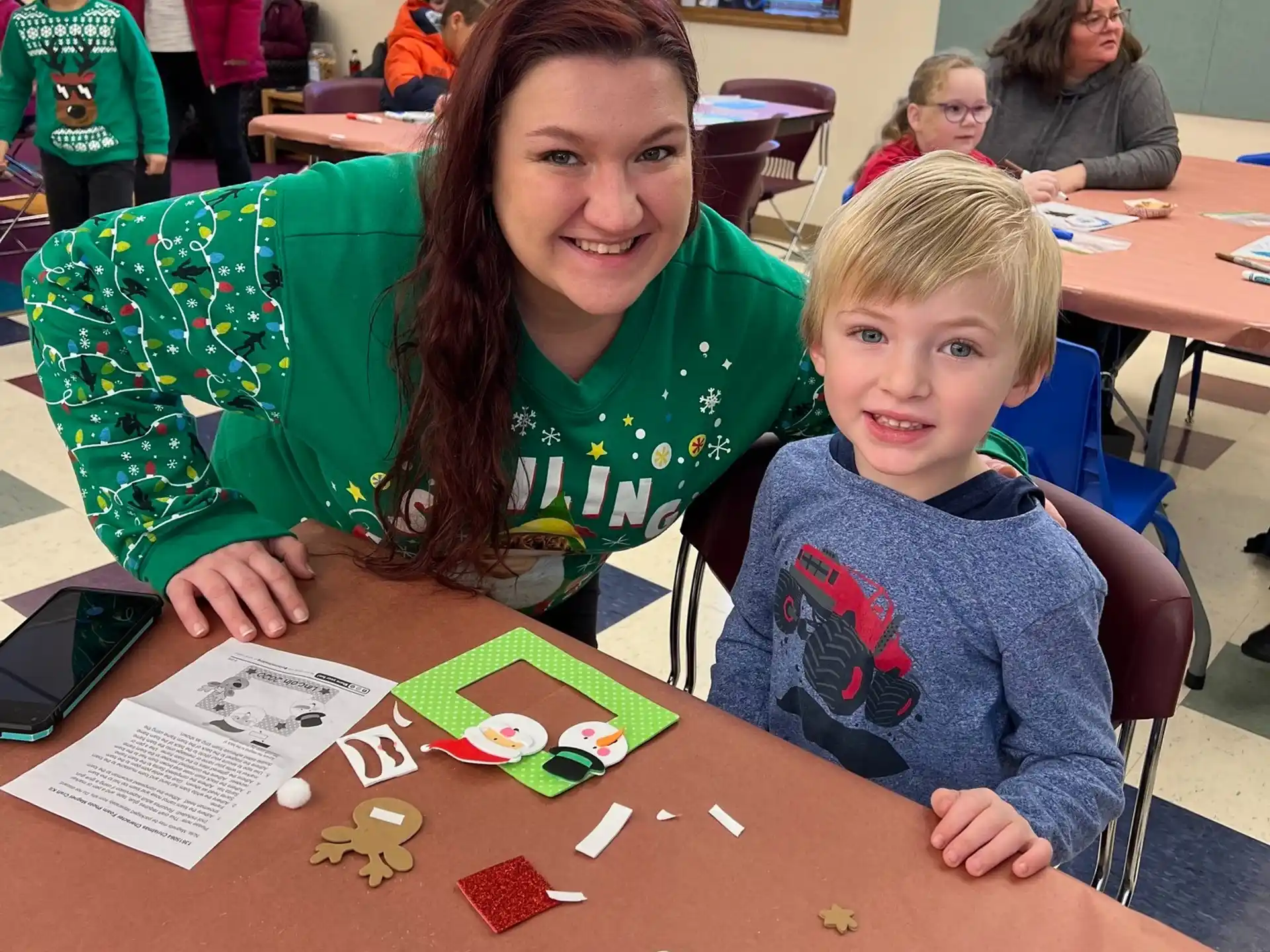 a person and a boy sitting at a table with a board game