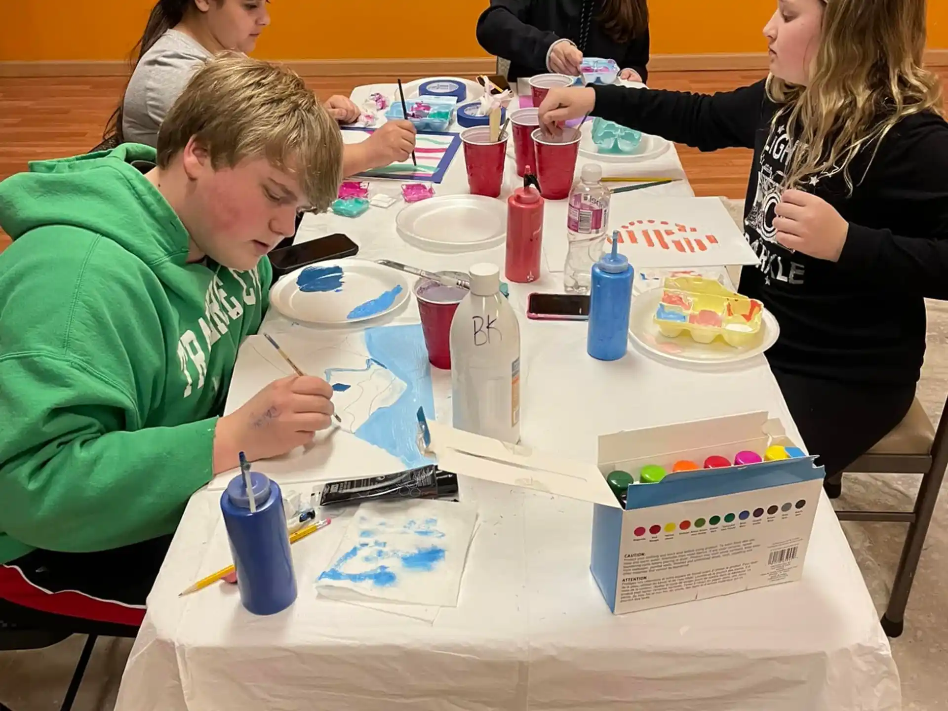 a group of people sitting at a table with food and drinks