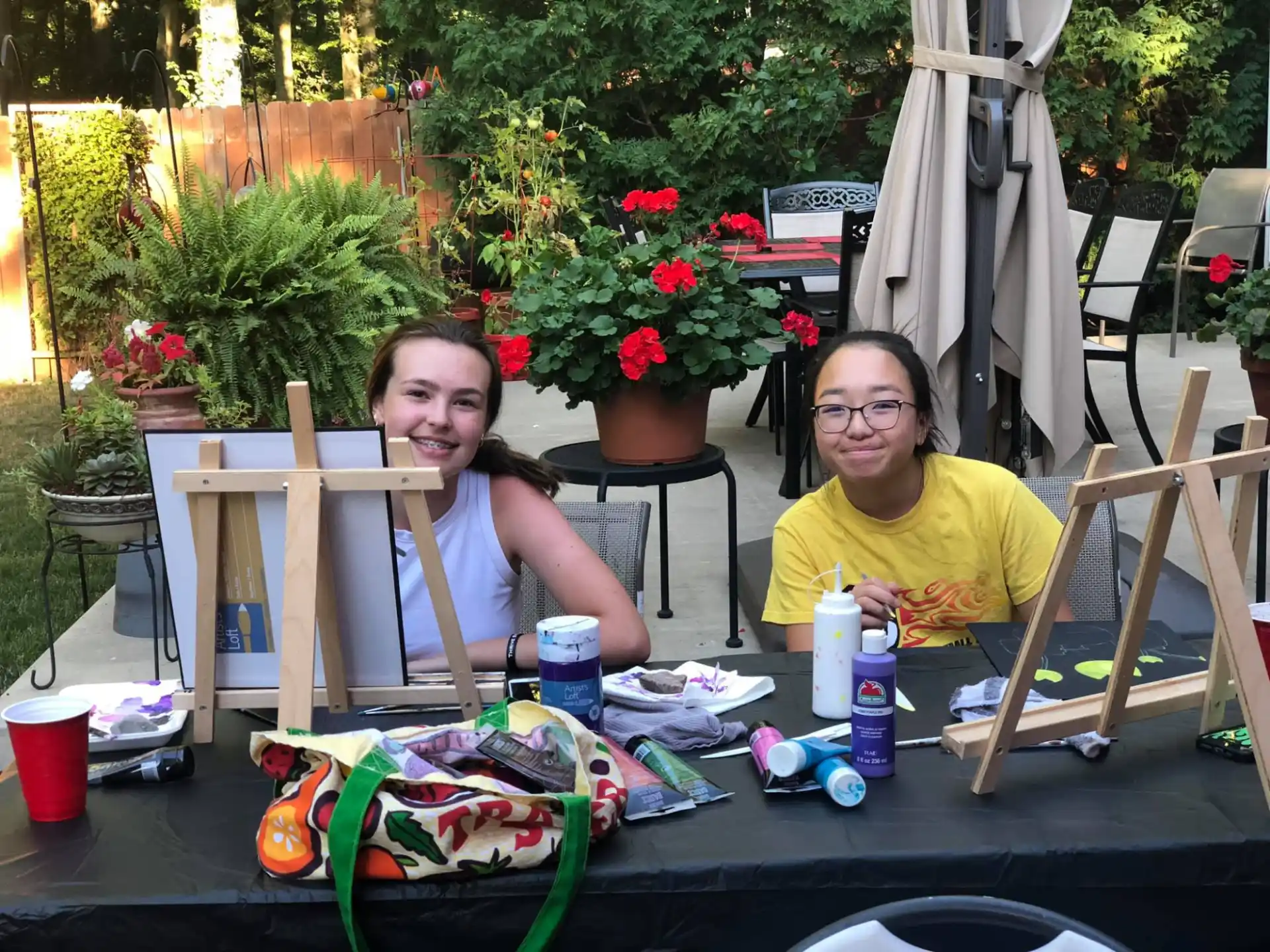 a person and a girl sitting at a table outside