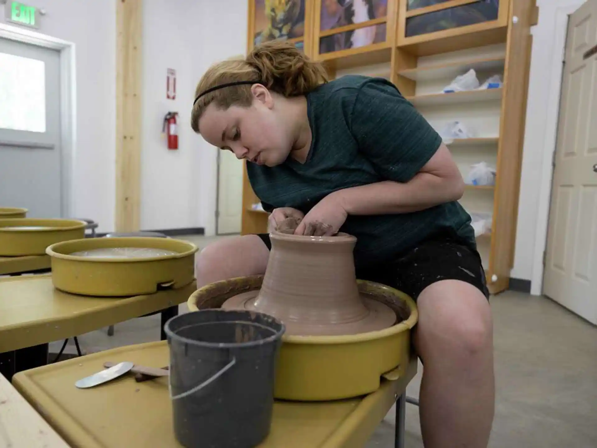 a person making a clay pot