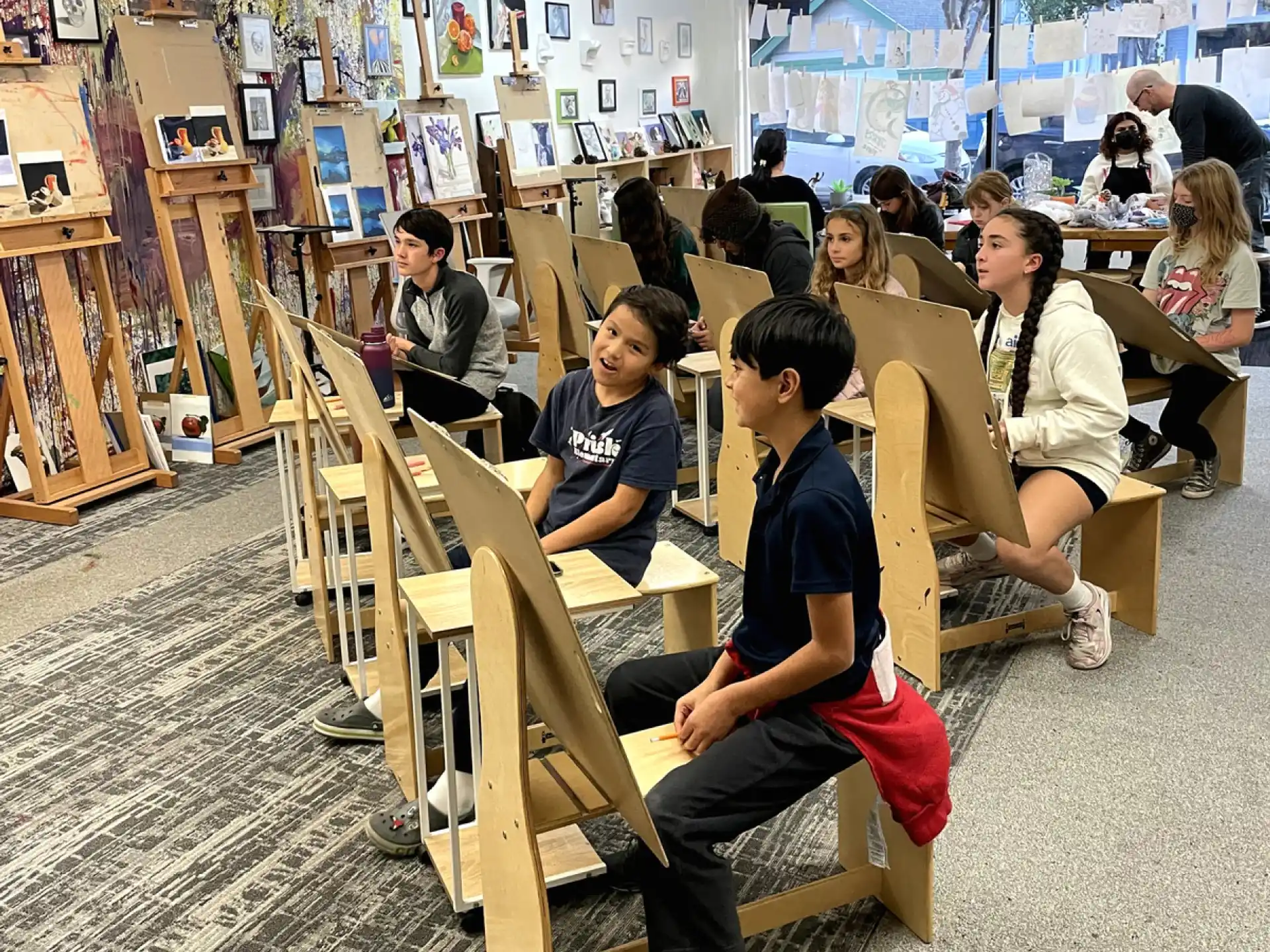 a group of people sitting in a room with books on shelves