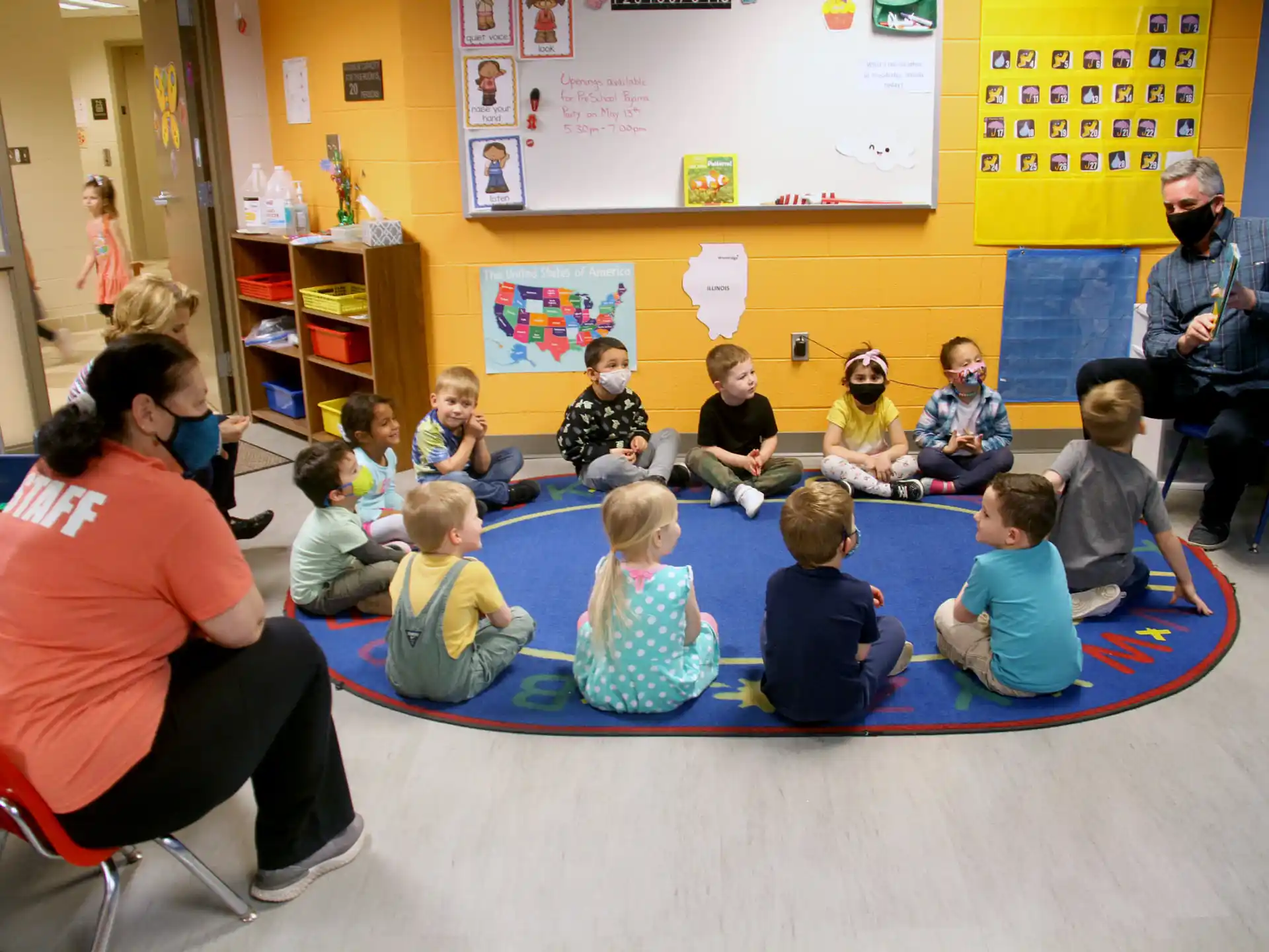 a group of children sitting on the floor in a classroom