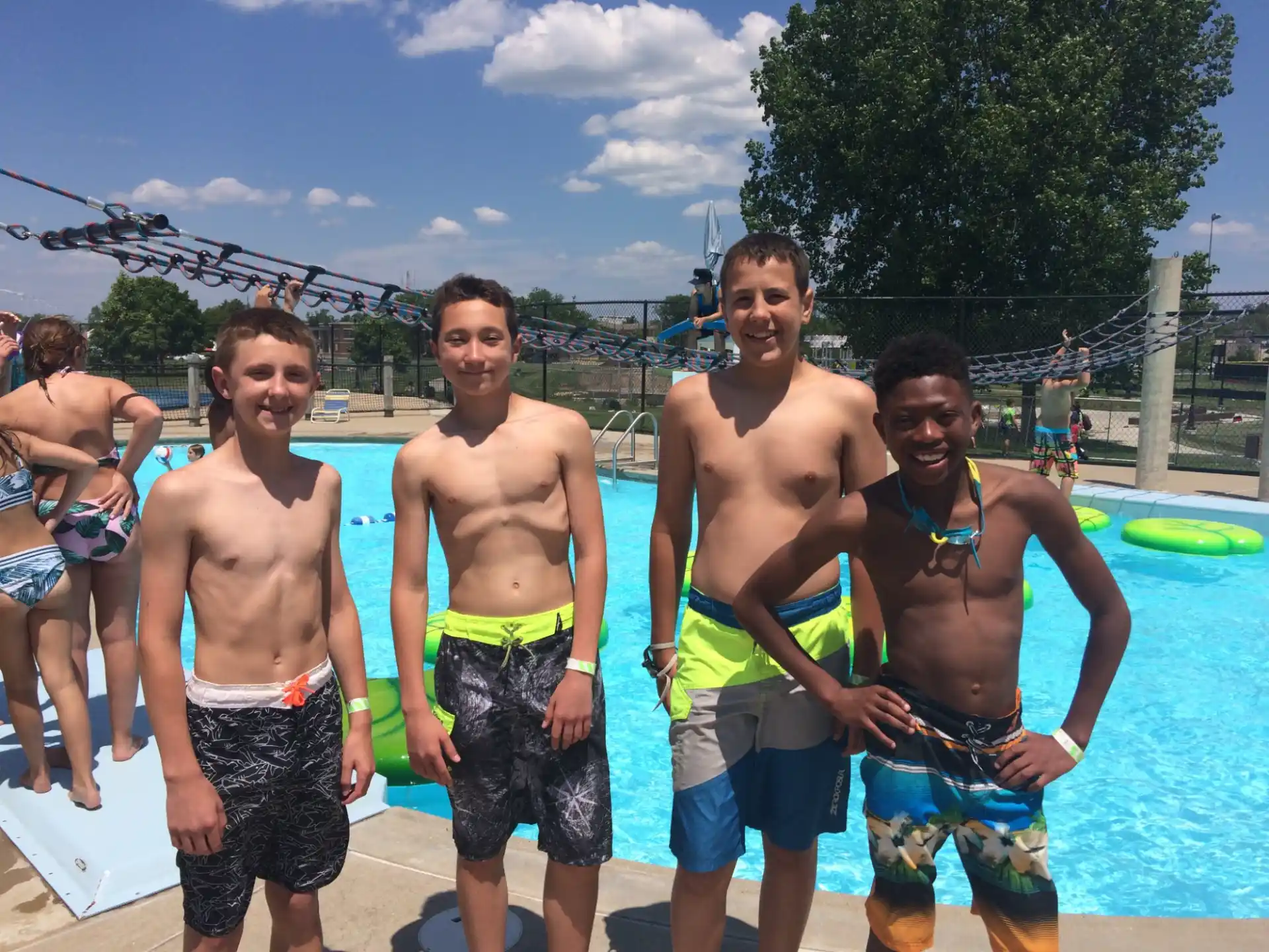 a group of men in swimsuits standing by a pool
