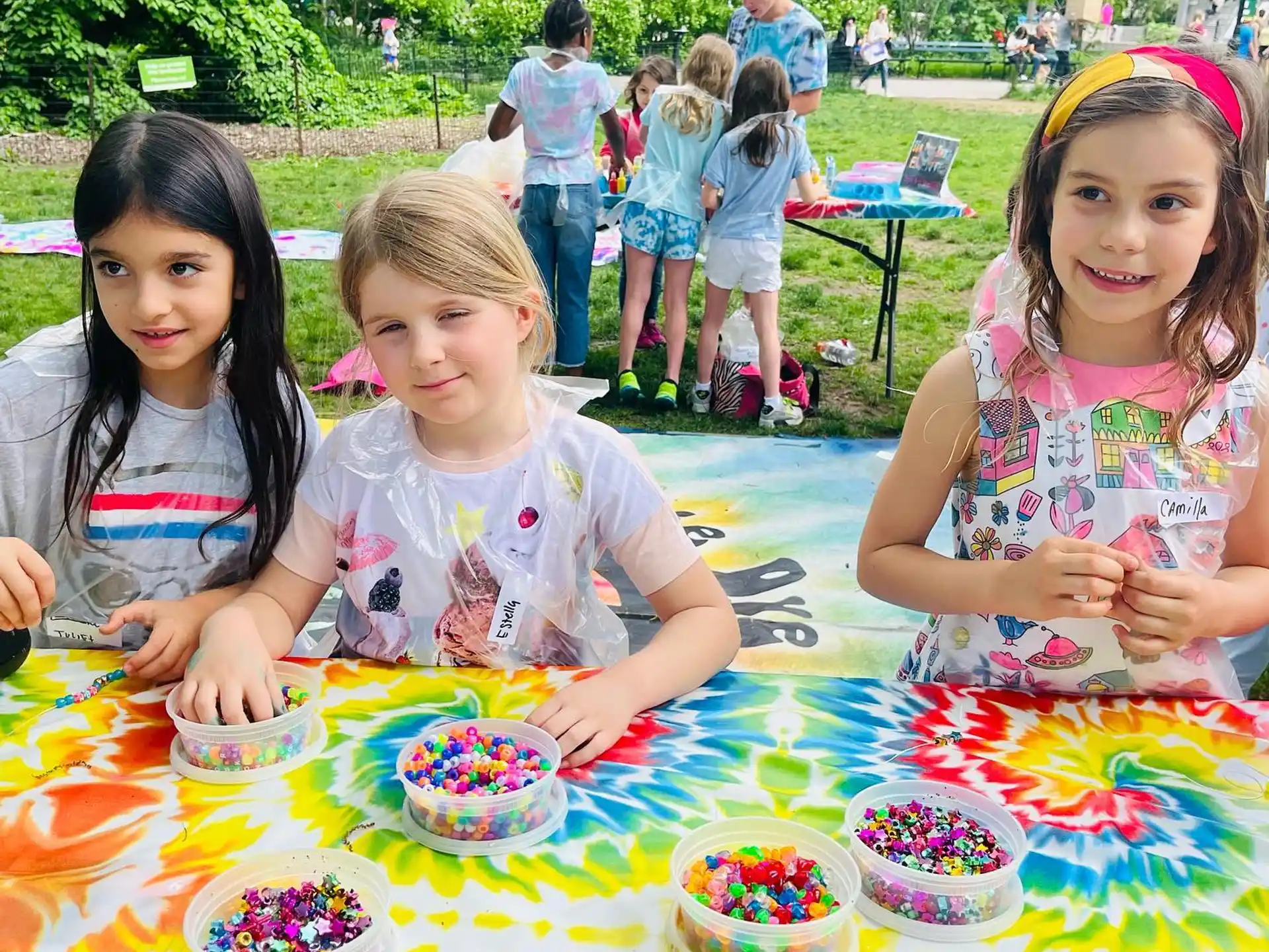 a group of children sitting at a table with food on it