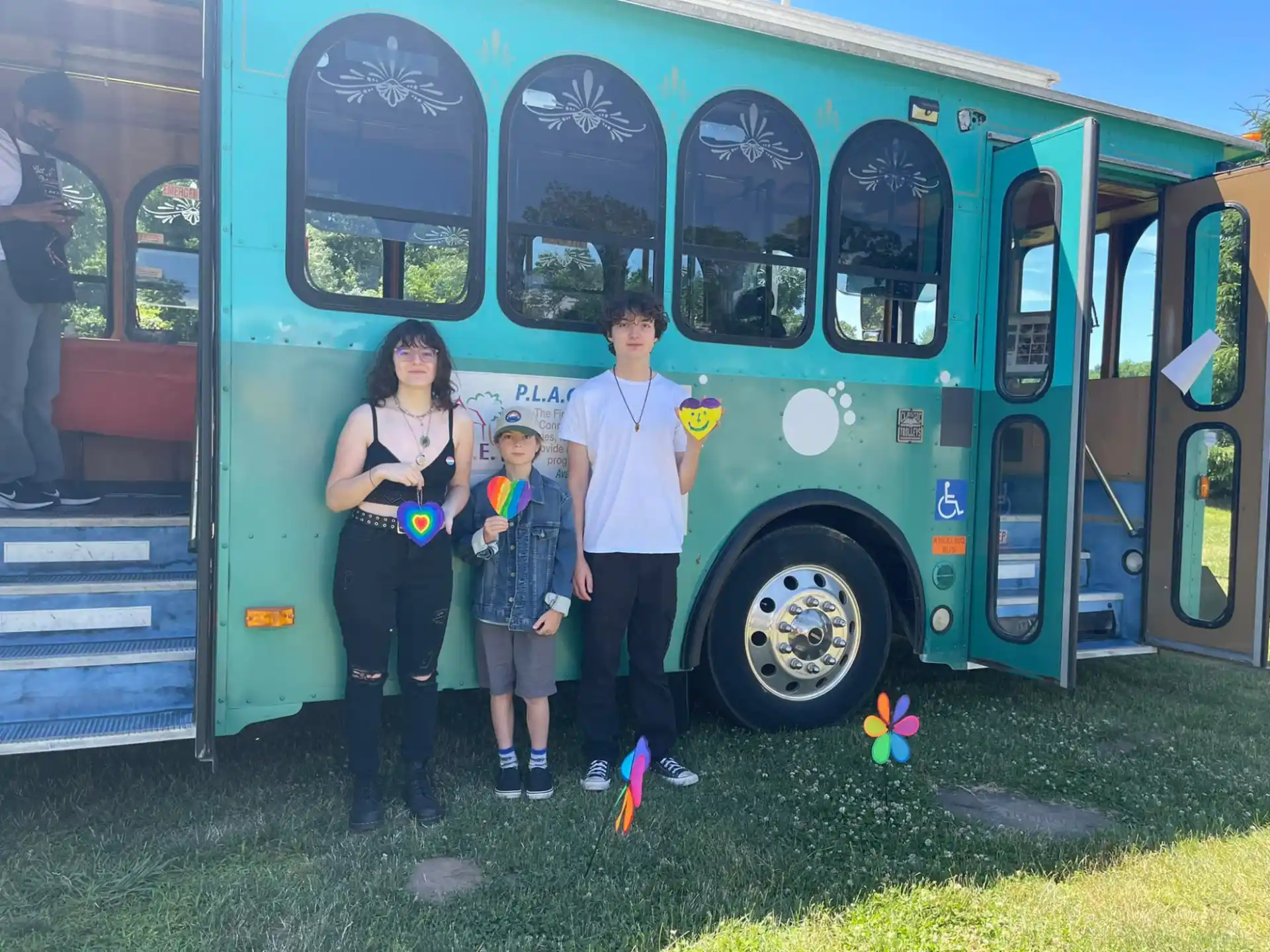 a family posing in front of a blue bus