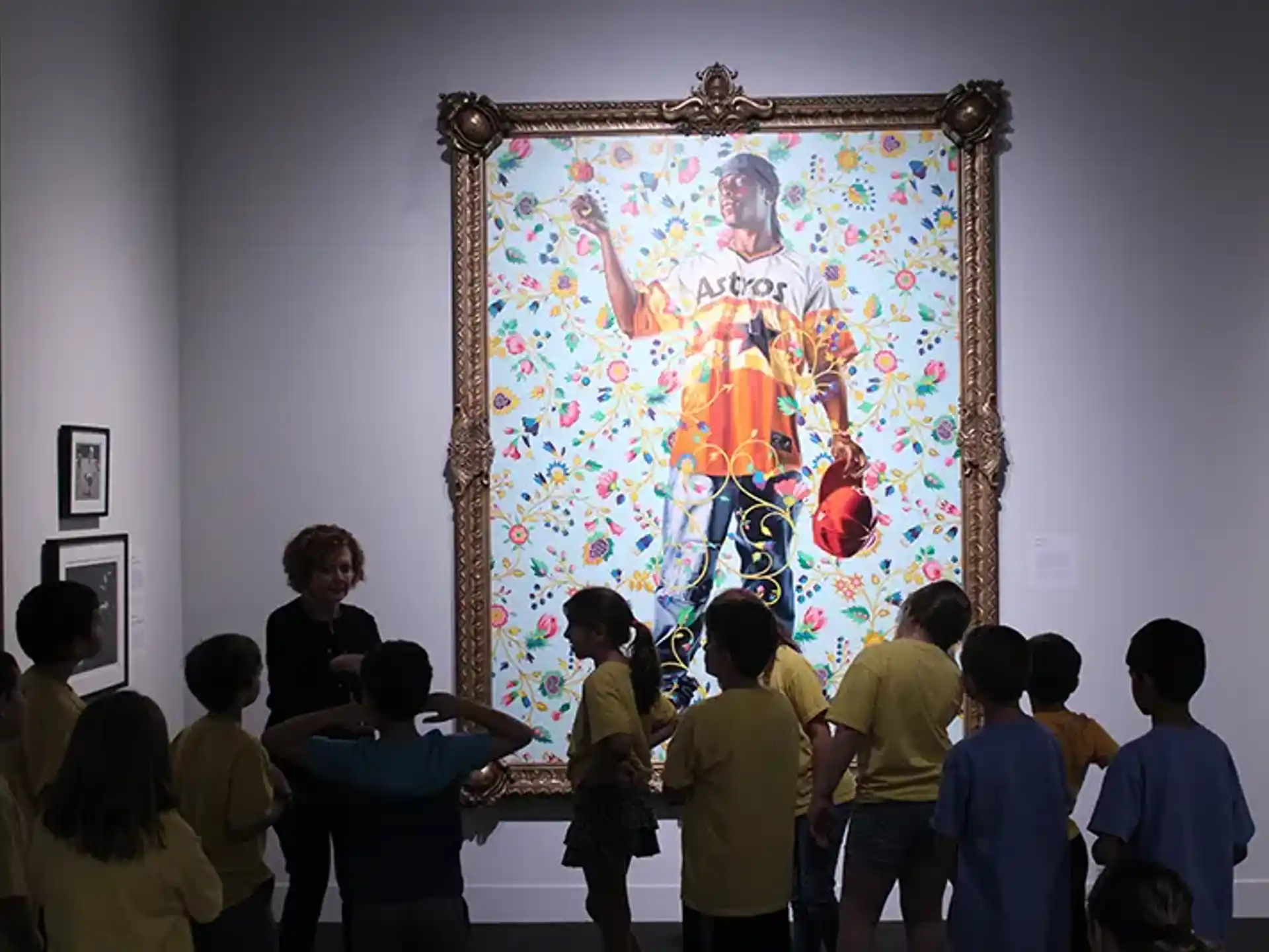 a group of people looking at a painting on a wall