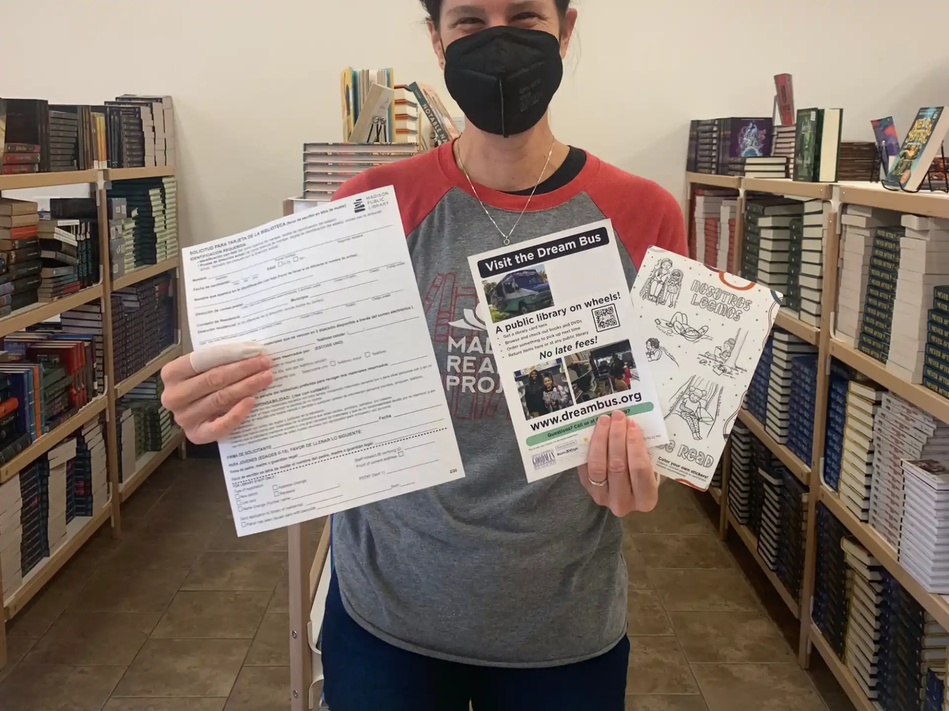 a person holding a paper and a mask in a library