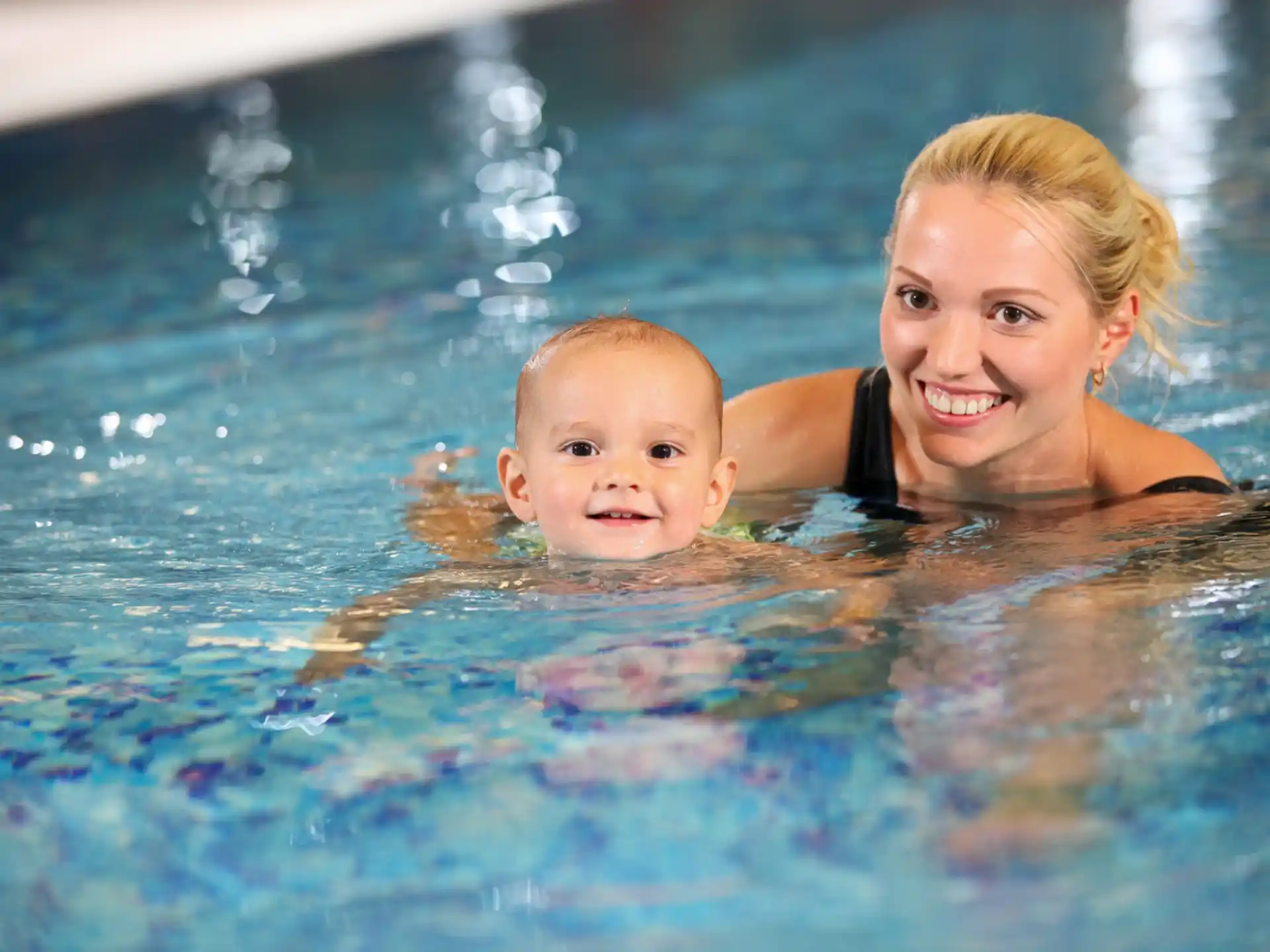 a person and a baby in a pool