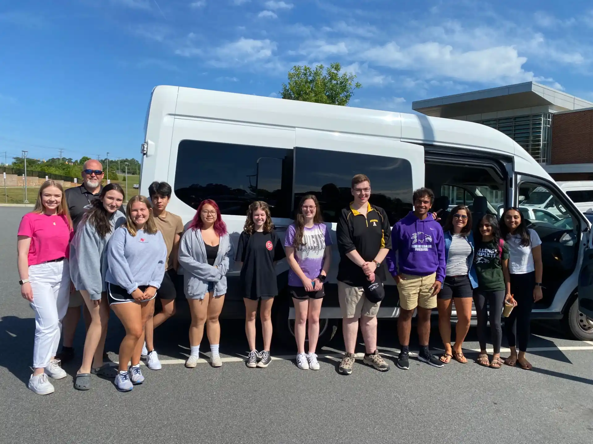 a group of people posing for a photo in front of a bus