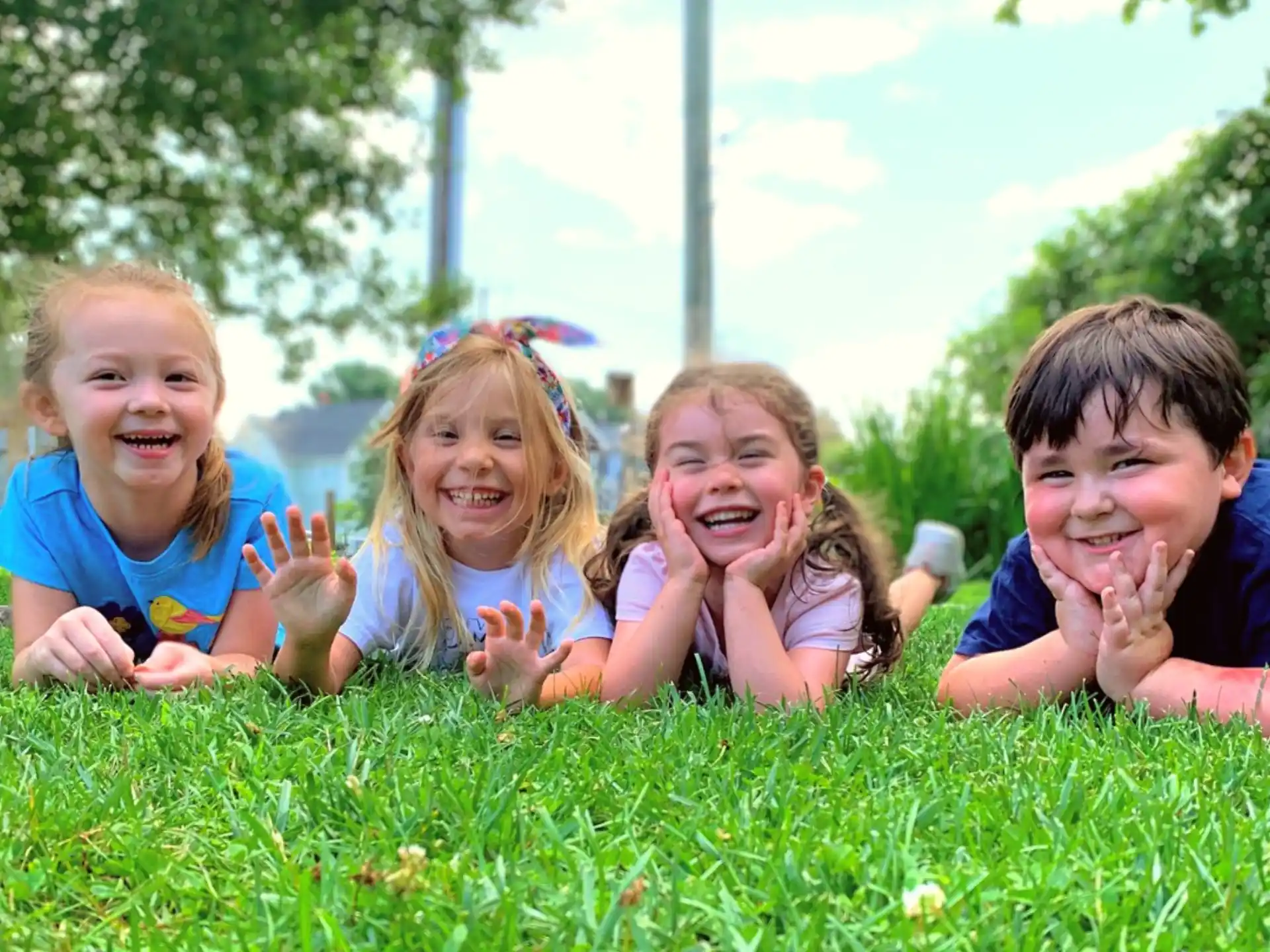 a group of children lying in the grass
