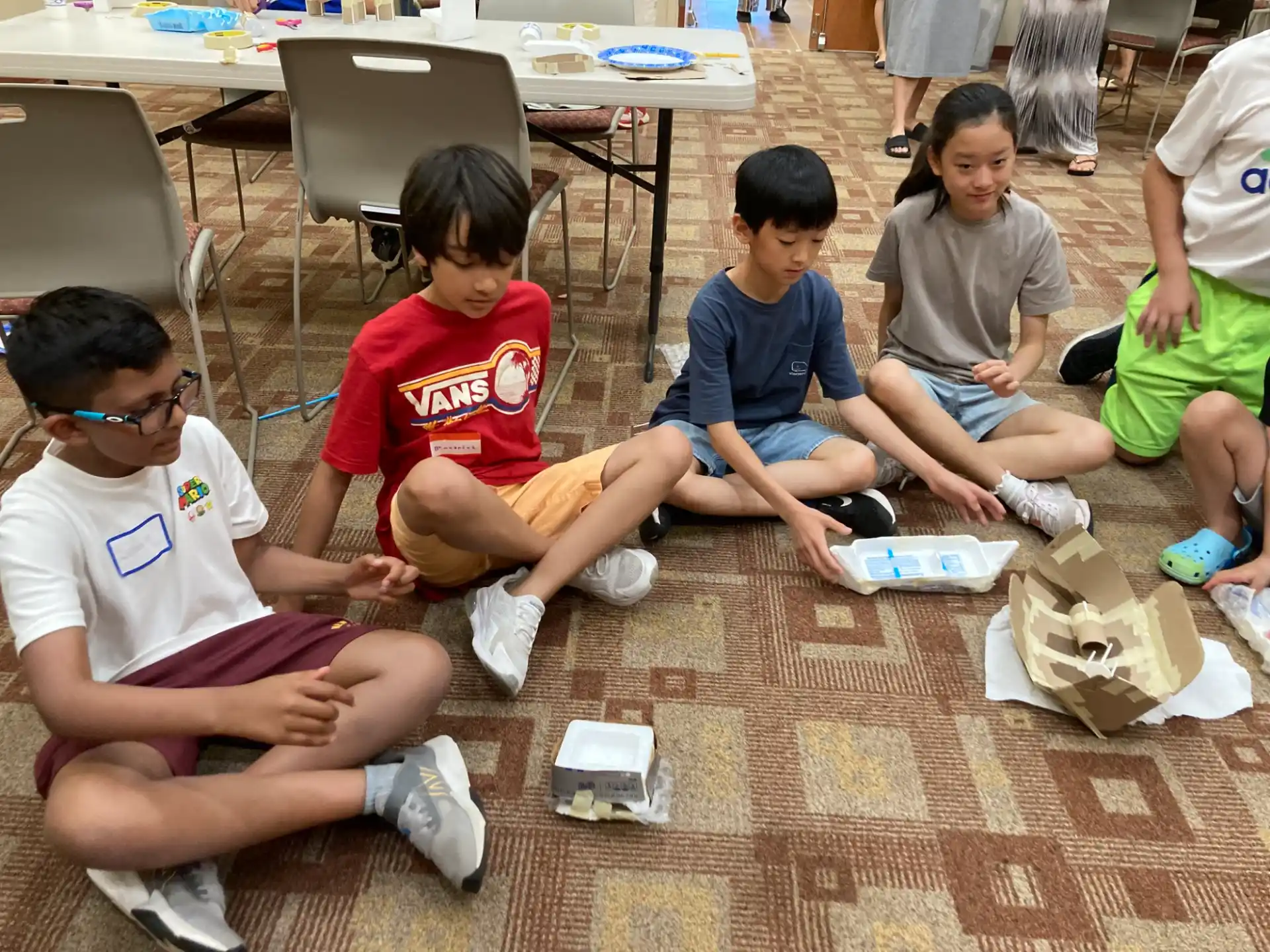 a group of children sitting on the floor playing a game
